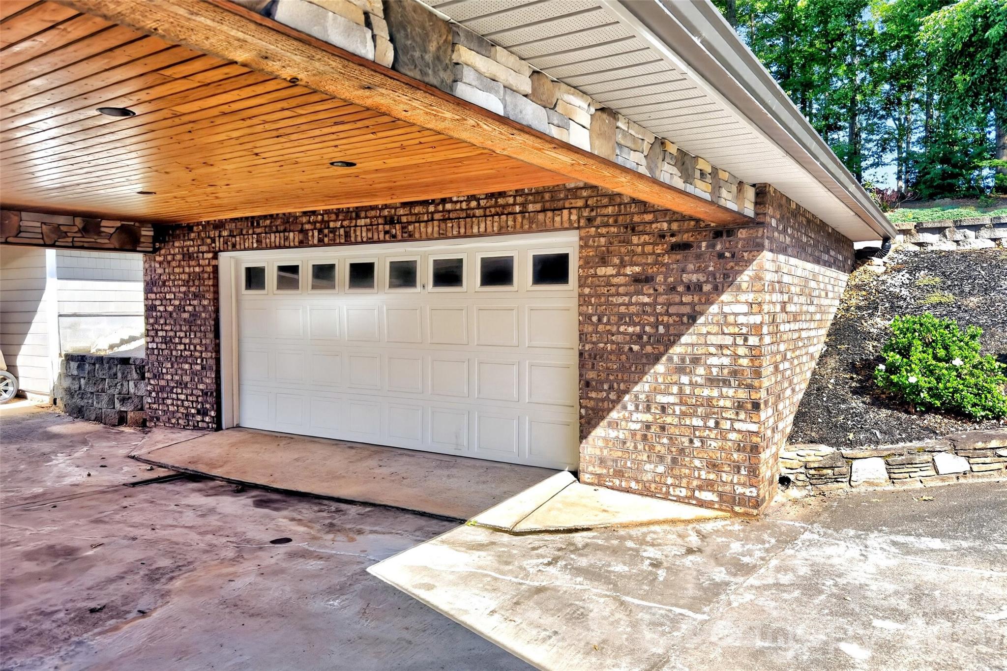 Attached carport with brick surround and concrete driveway at the street-side approach. - 831 Lake Club Drive, Nebo