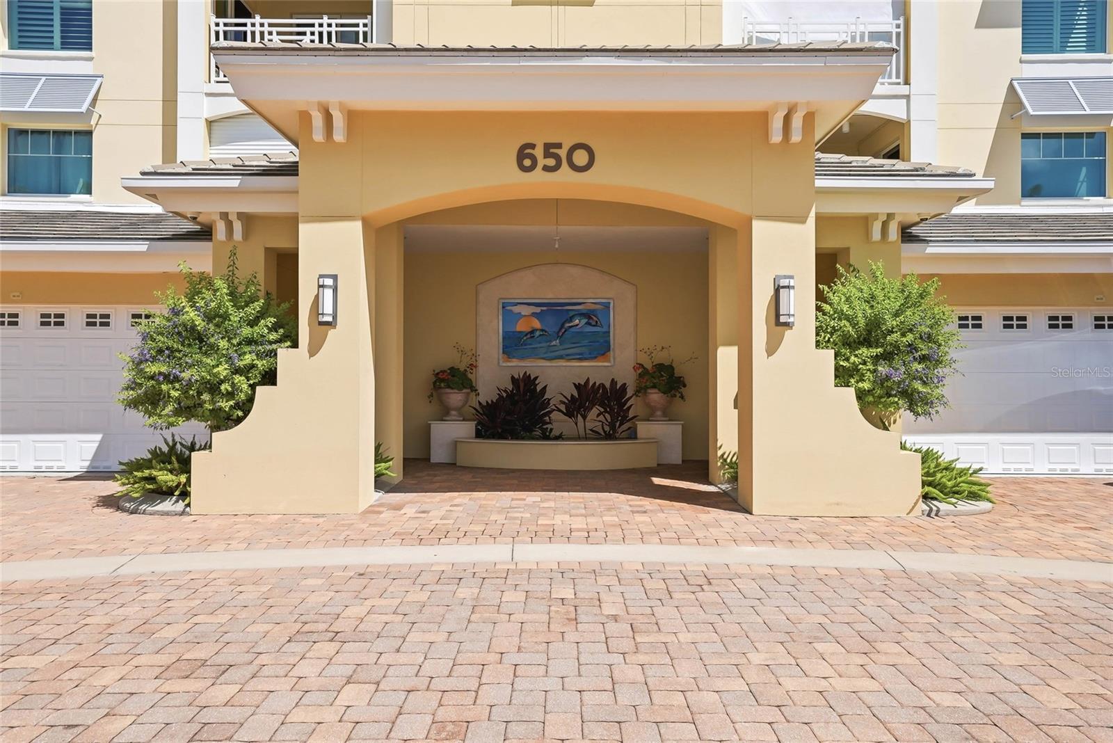 Private secured building entrance with elegant coastal architecture. - 650 COLLANY RD #401, TIERRA VERDE