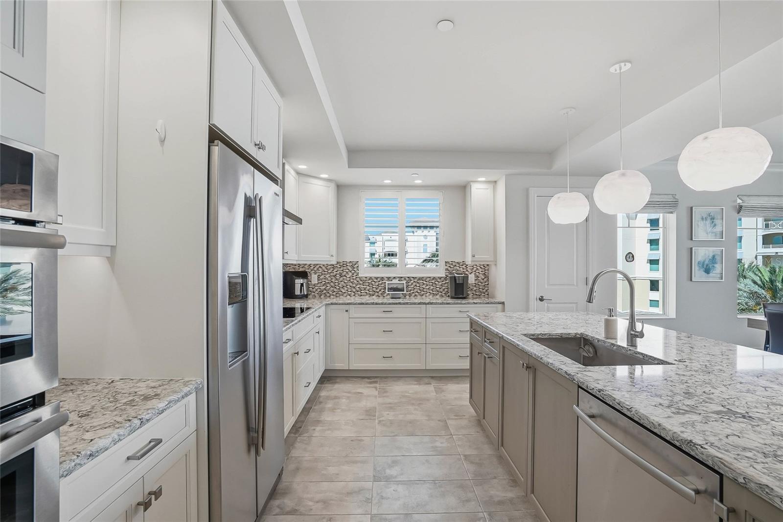 Bright kitchen with stone countertops and generous cabinetry. - 650 COLLANY RD #401, TIERRA VERDE