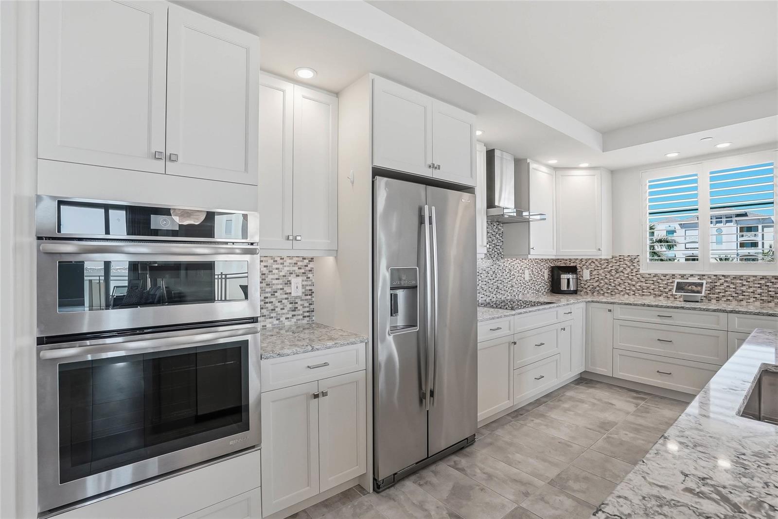 Beautifully designed kitchen with coastal-inspired finishes and Jenn-Air appliances. - 650 COLLANY RD #401, TIERRA VERDE