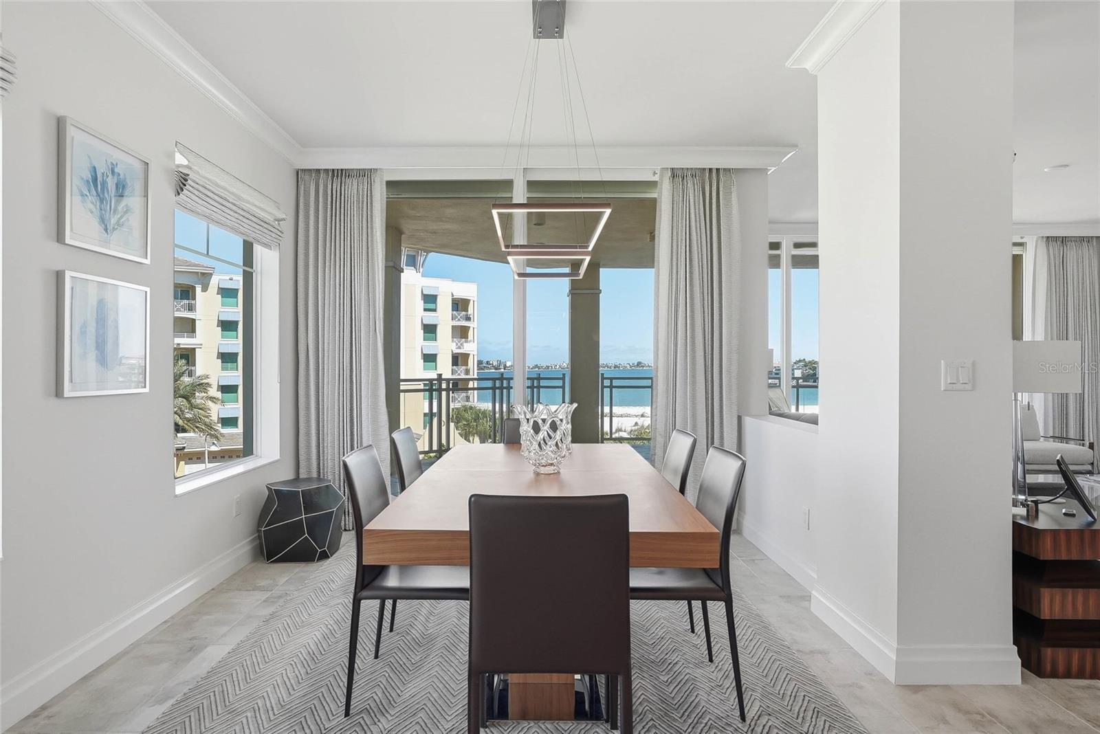 Dedicated dining area with a cool, modern chandelier and magnificent water views. - 650 COLLANY RD #401, TIERRA VERDE
