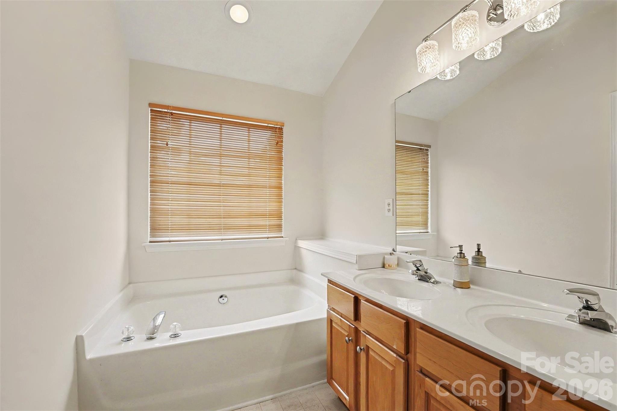 Primary suite full bathroom features garden tub, double sinks, and stand up shower - 9866 Treeside Lane, Matthews