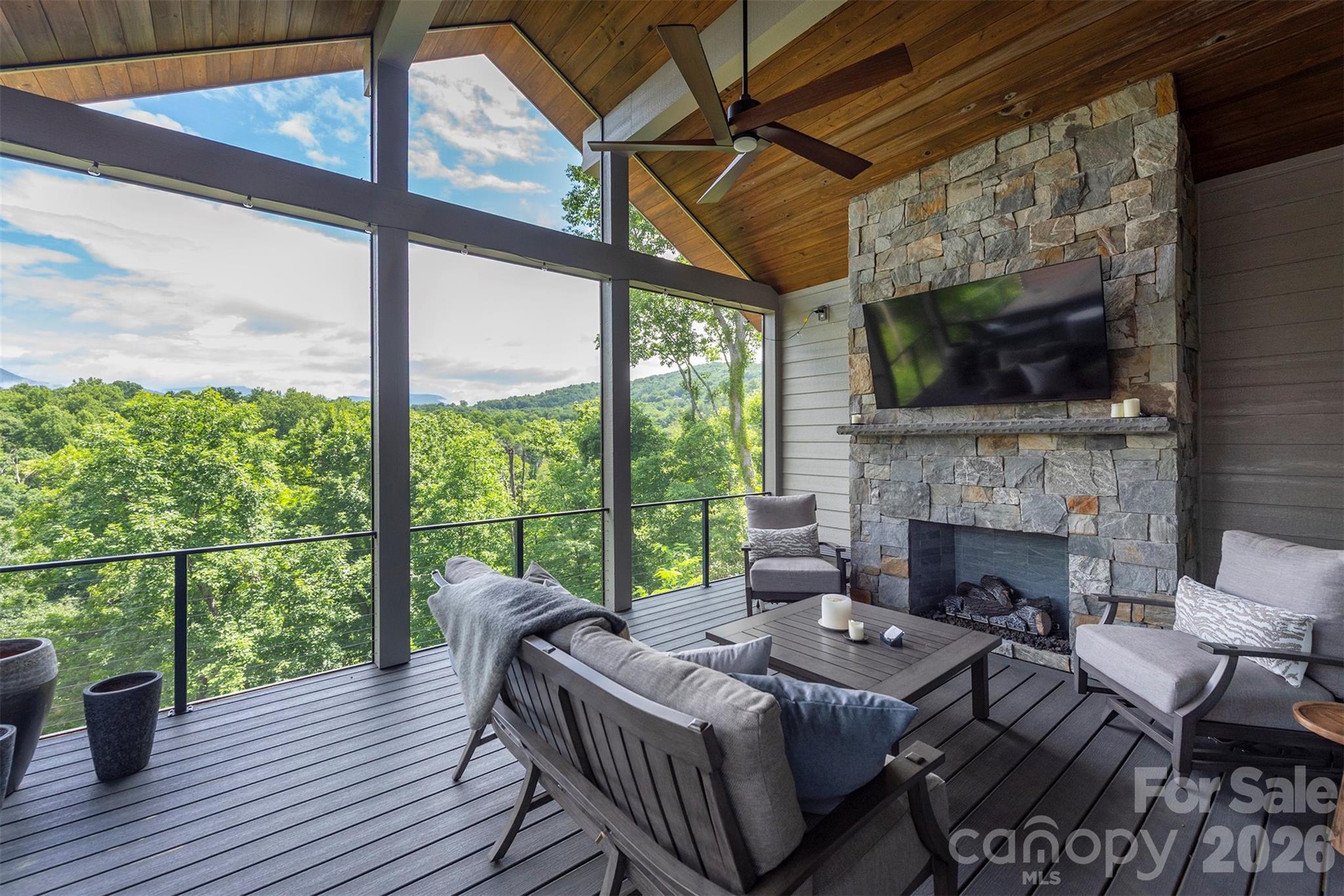 Enjoy the main level covered porch with gas fireplace and mountain views - 158 Riverbend Forest Drive, Asheville