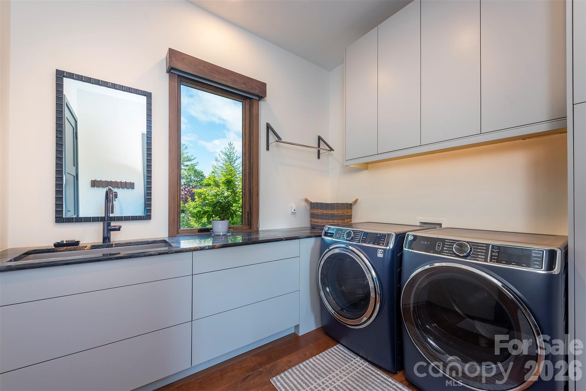 Laundry room just off garage entrance with sink and amazing storage space - 158 Riverbend Forest Drive, Asheville