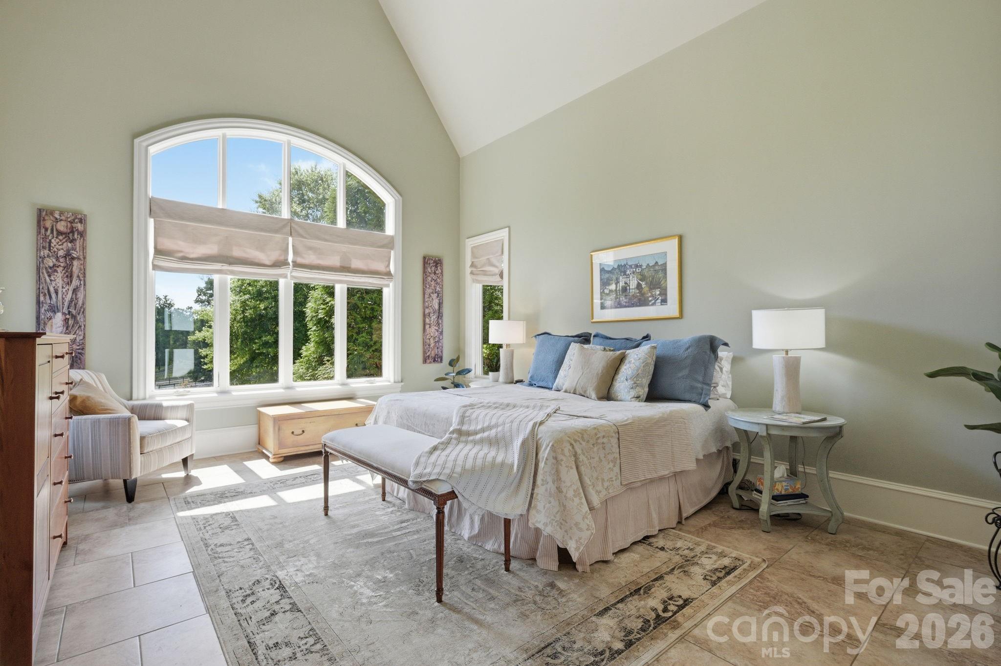 Main floor primary suite with tile floors, glass door opening to screen porch and pasture views - 8528 Waxhaw Creek Road, Waxhaw