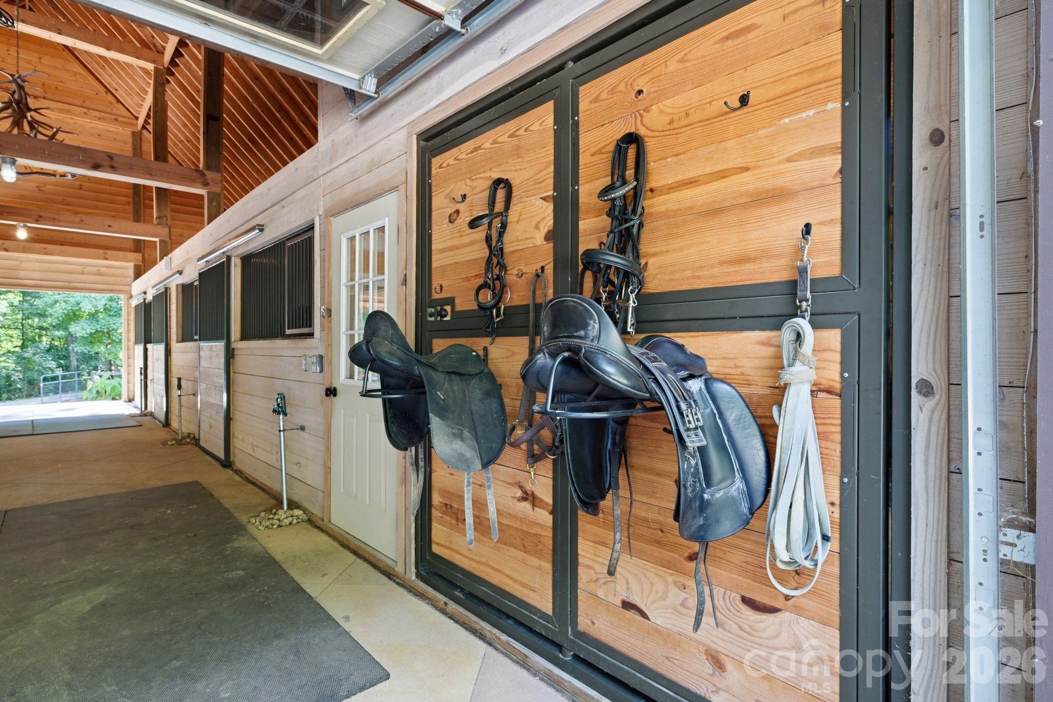 Concrete center aisle, walk up hay and storage deck, electronic garage door and sliding end doors - 8528 Waxhaw Creek Road, Waxhaw