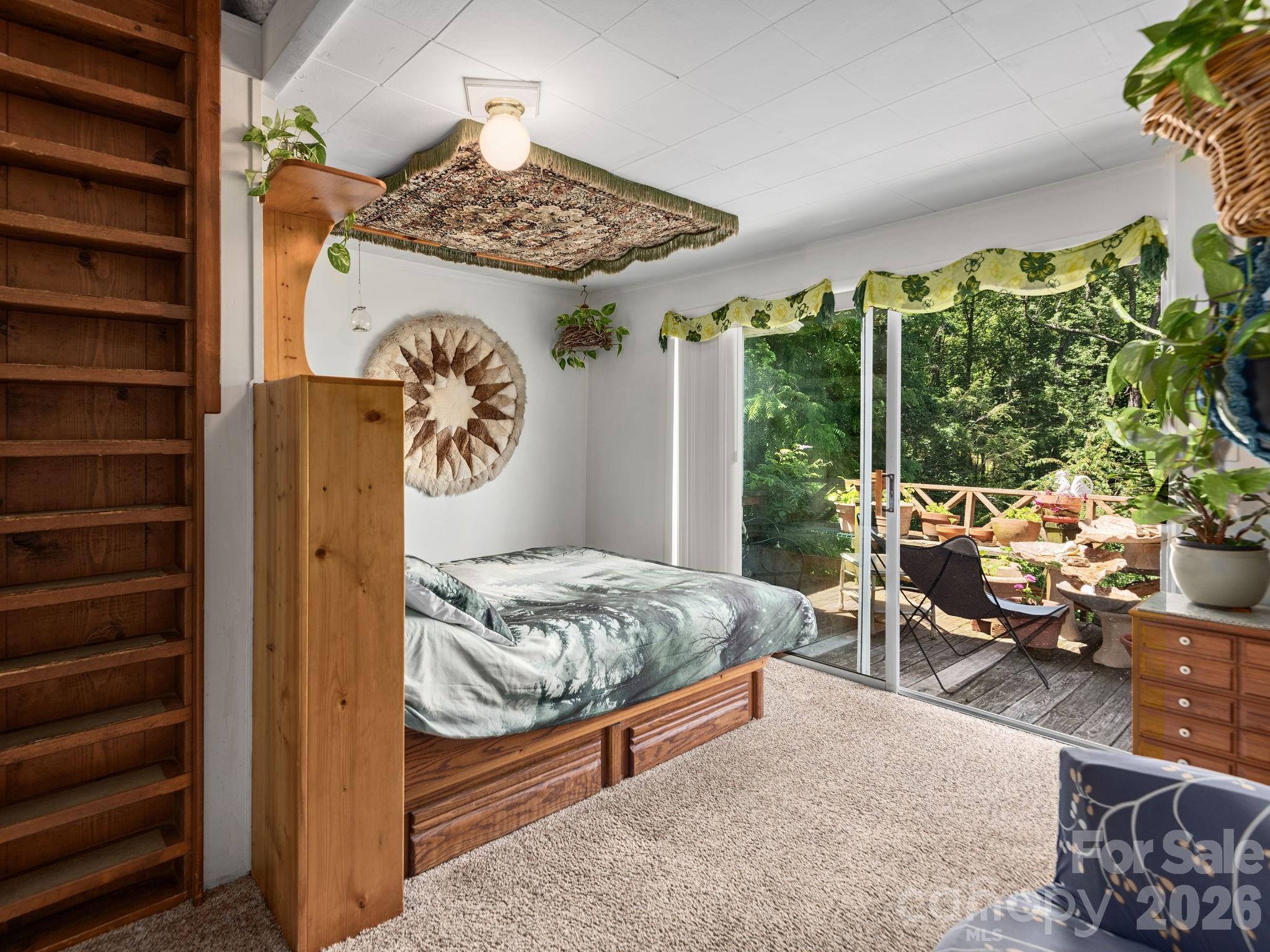 Primary bedroom has direct deck access and ladder leading to loft area - 46 Perennial Ridge, Weaverville
