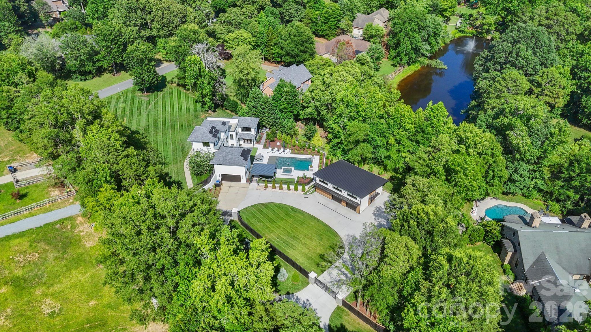 Aerial view of expansive 1.58-acre lot with resort-style backyard and modern architecture - 1064 Greylyn Drive, Matthews