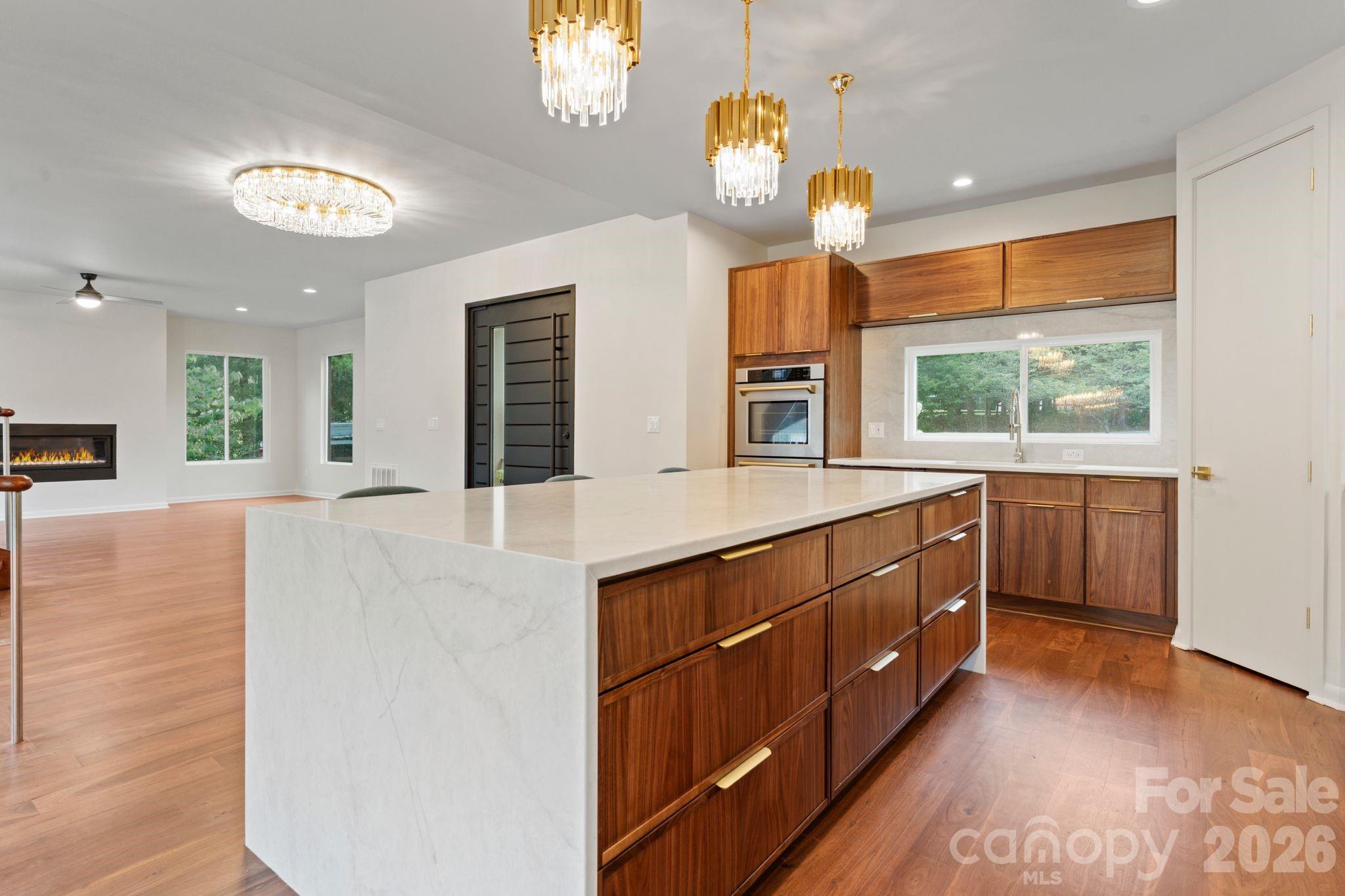 Luxury kitchen featuring custom oak cabinetry, full backsplash, and high-end stainless steel appliances - 1064 Greylyn Drive, Matthews