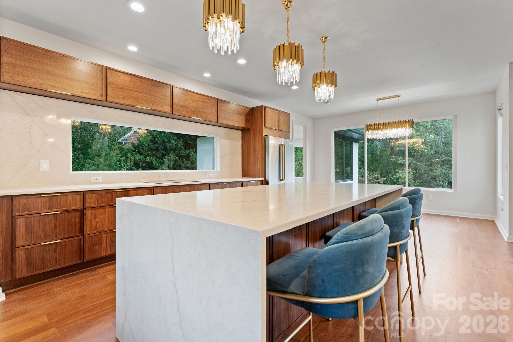 Designer kitchen with custom cabinetry, waterfall island, and professional-grade appliances - 1064 Greylyn Drive, Matthews