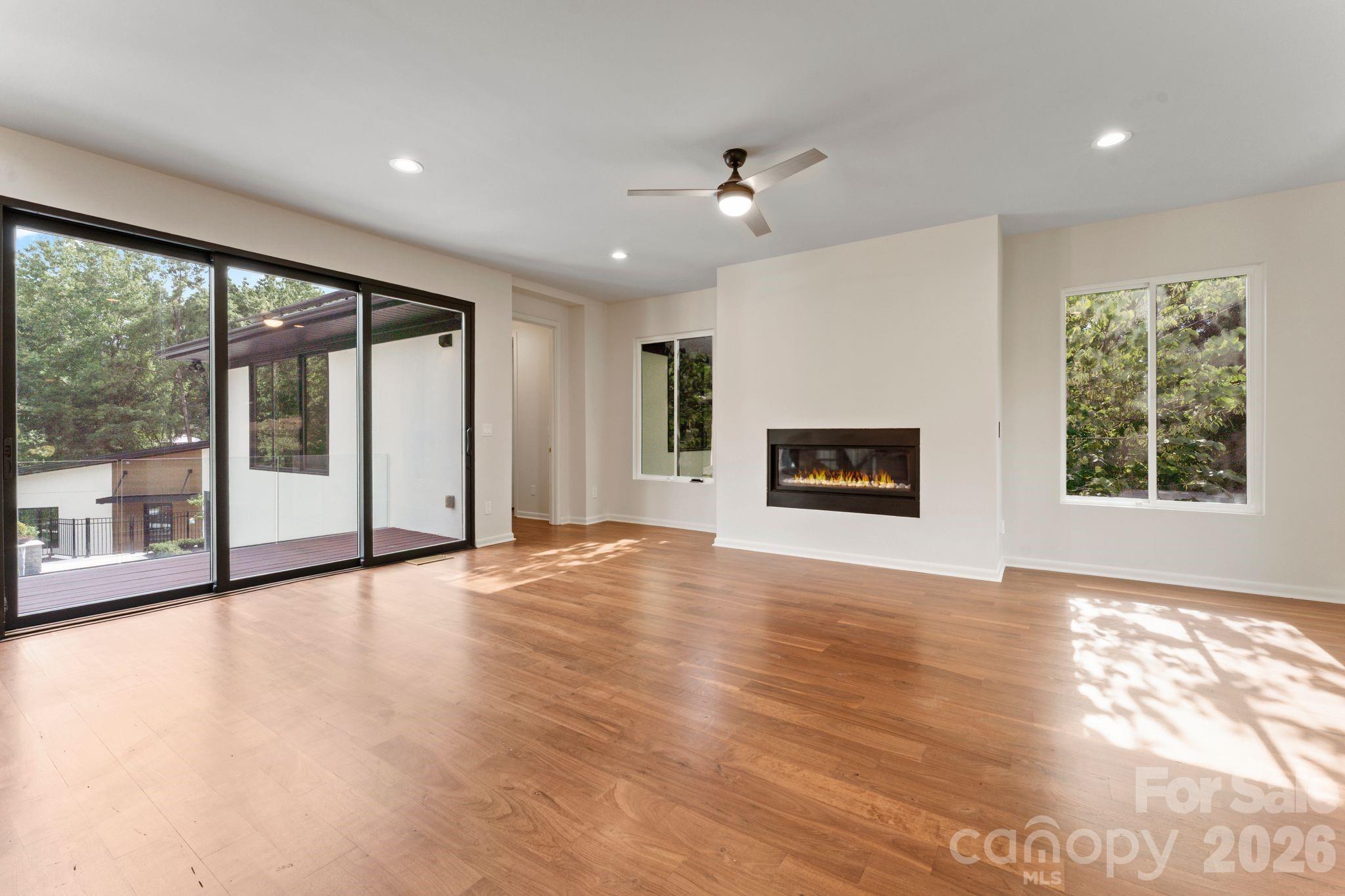 Bright open-concept living room with oak hardwood floors and cozy gas fireplace - 1064 Greylyn Drive, Matthews