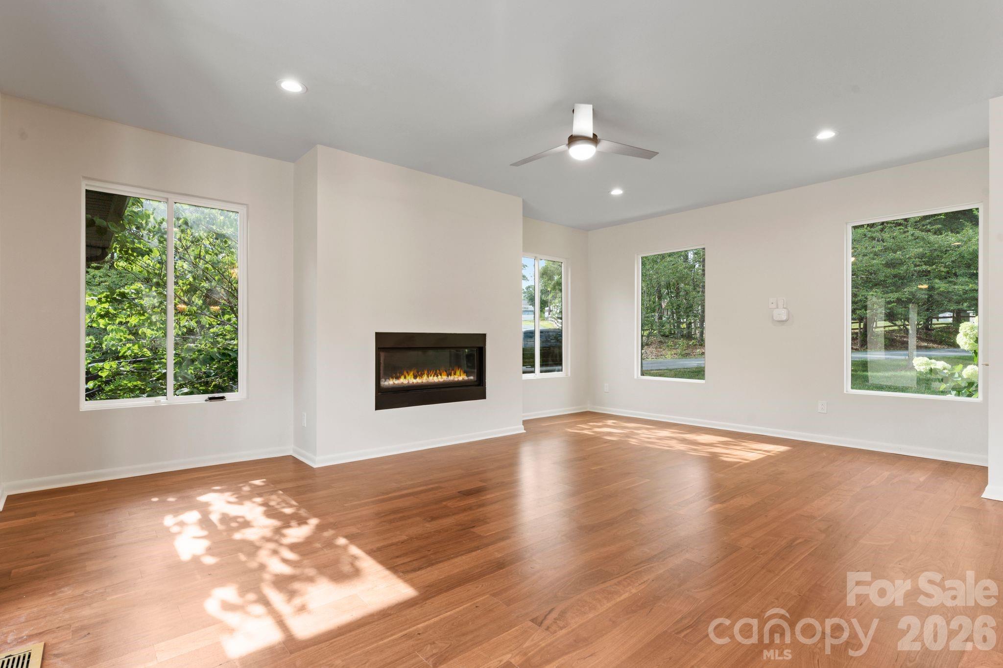 Open living area with oak hardwood floors, gas fireplace, and tons of natural light - 1064 Greylyn Drive, Matthews