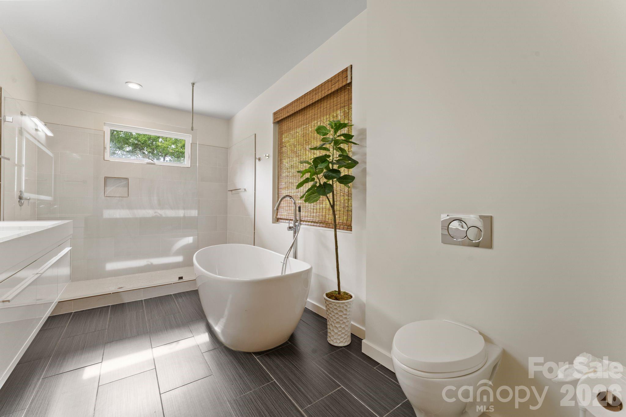 Primary en-suite spa bath featuring dual vanities, walk-in shower, and soaking tub - 1064 Greylyn Drive, Matthews