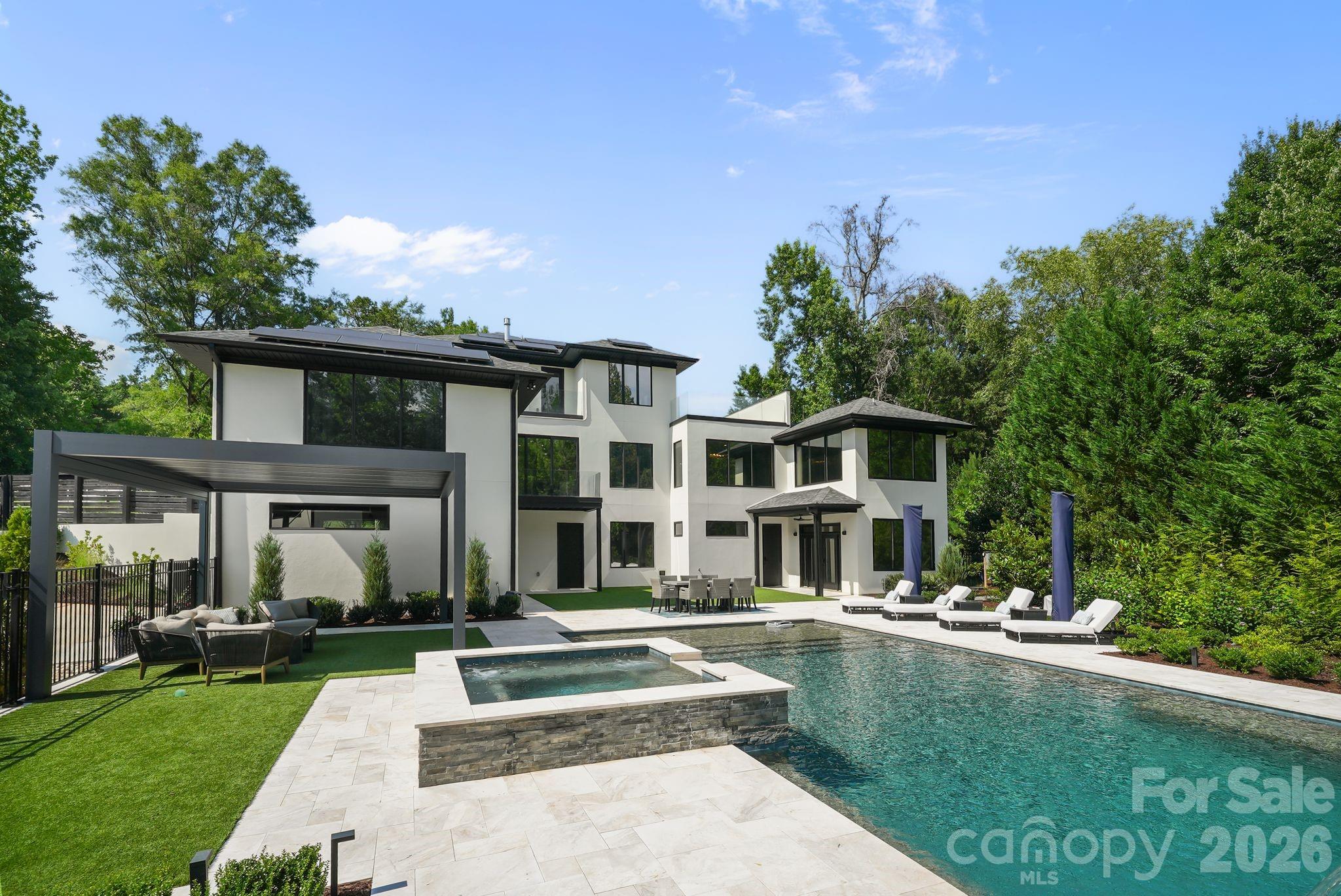 Resort-style pool with sheer-descent waterfalls, tanning ledge, and leathered marble surround - 1064 Greylyn Drive, Matthews