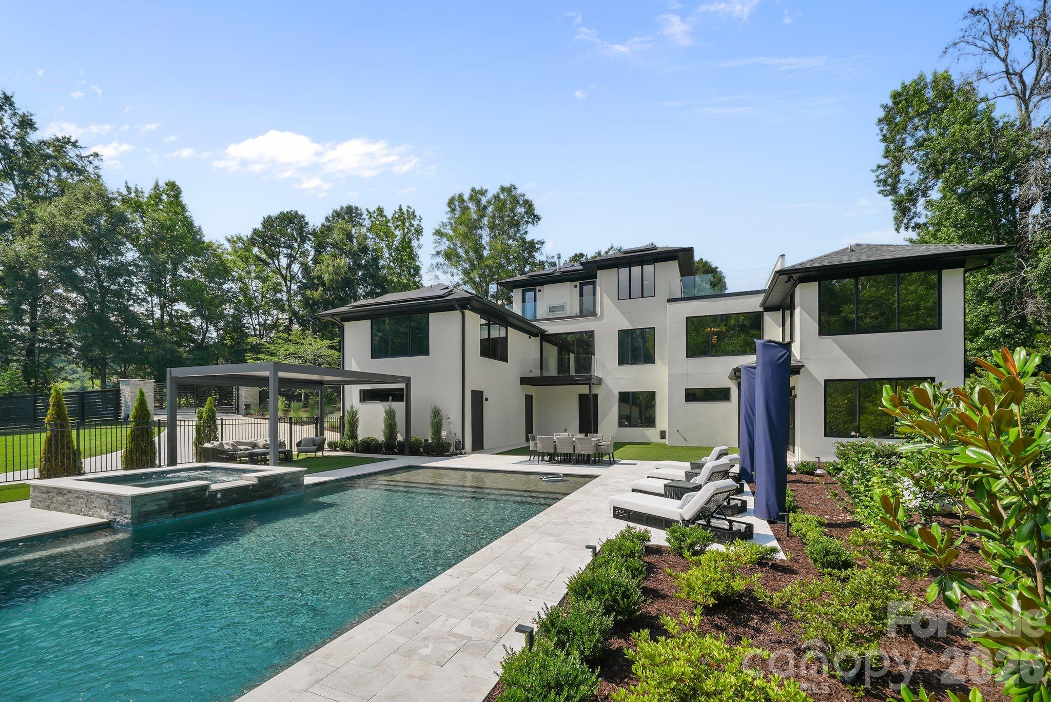 Resort-style pool with sheer-descent waterfalls, tanning ledge, and leathered marble surround - 1064 Greylyn Drive, Matthews