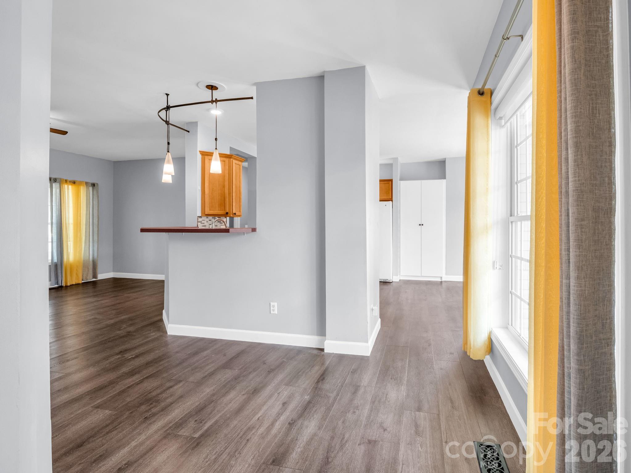 This is the view from the front door; you can walk straight into the kitchen or go left into the main living area. There is room for 2-3 barstools around the counter. - 355 Hidden Meadow Drive, Hendersonville