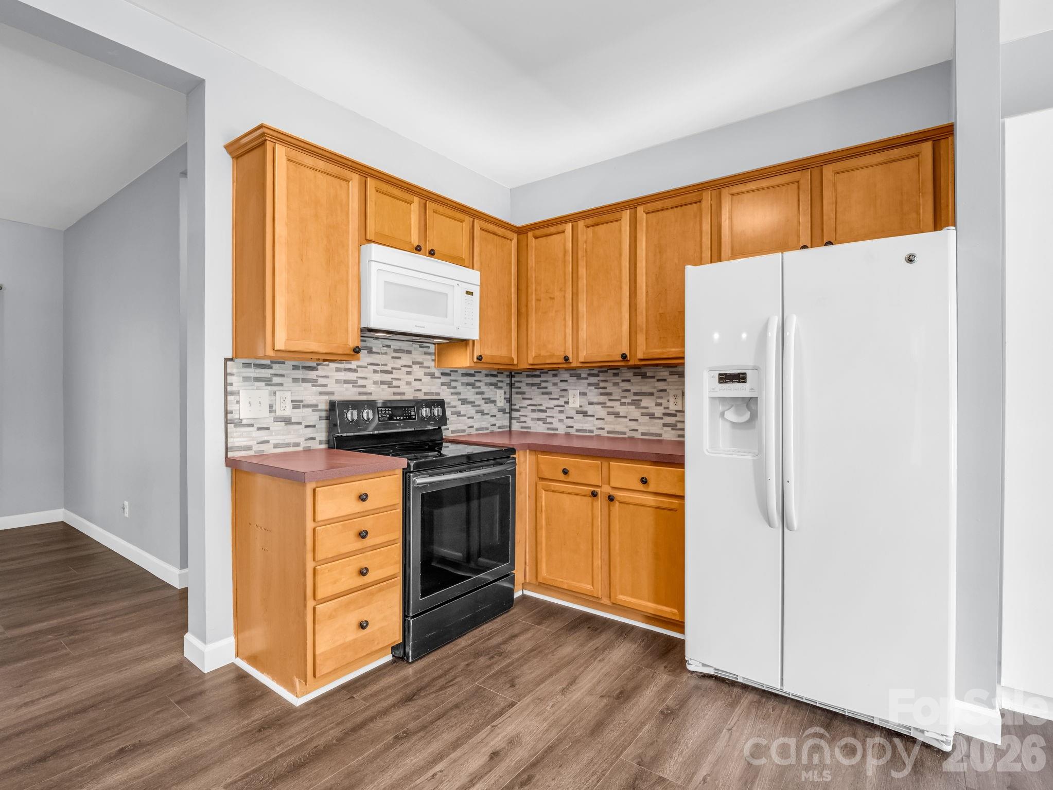 View of right side of kitchen with refrigerator, stove and microwave. - 355 Hidden Meadow Drive, Hendersonville