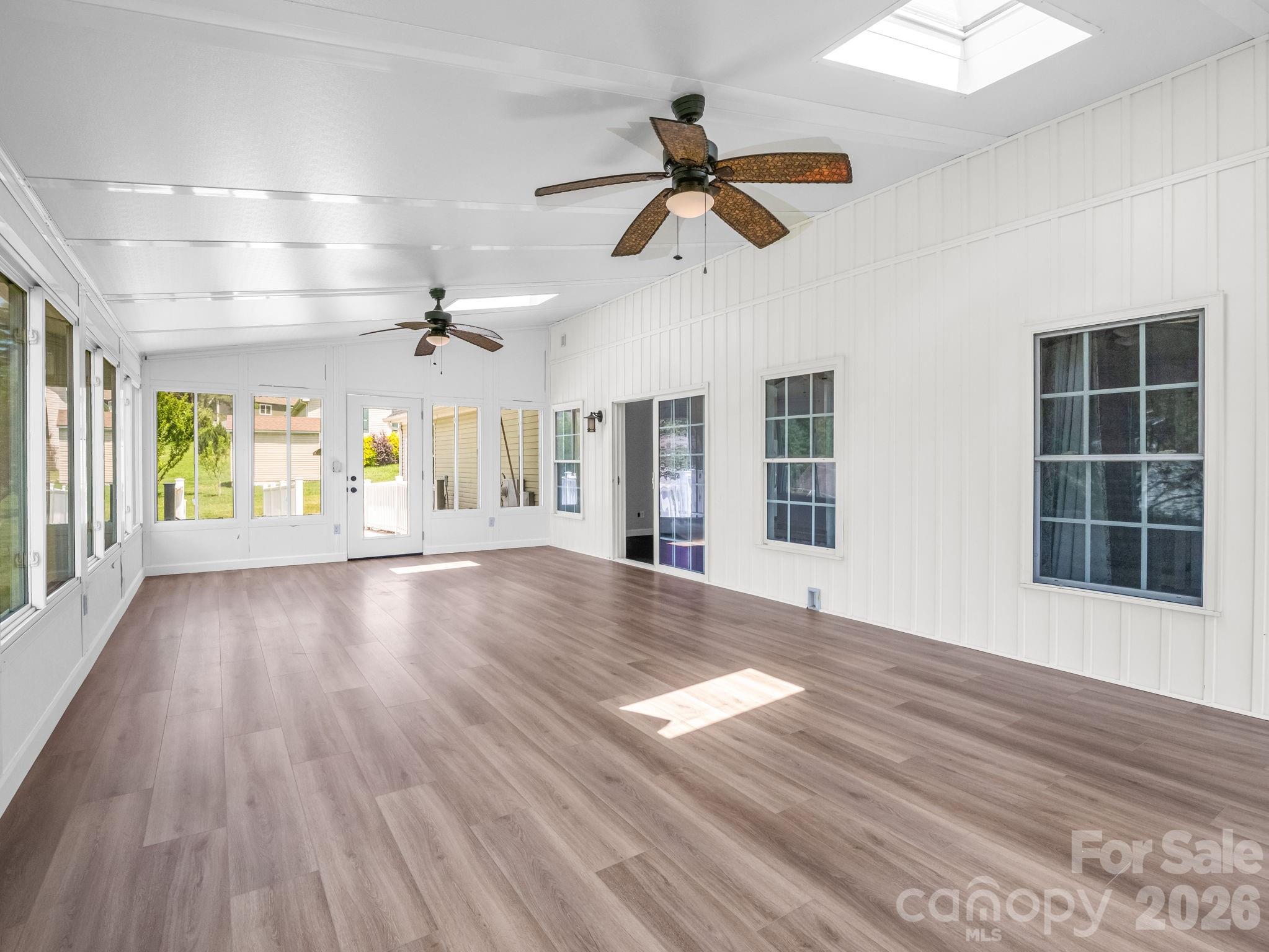 View of sunroom looking back to the entrance of living room and also exterior access to the back porch and backyard. - 355 Hidden Meadow Drive, Hendersonville