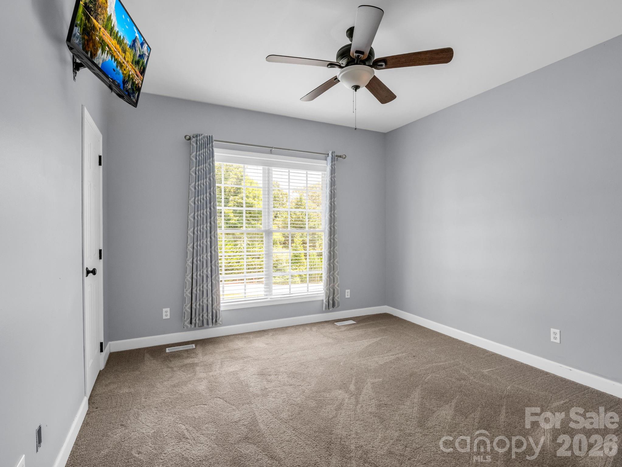 Bedroom # 1 looking into room from door; features walk-in closet. TV will convey. - 355 Hidden Meadow Drive, Hendersonville