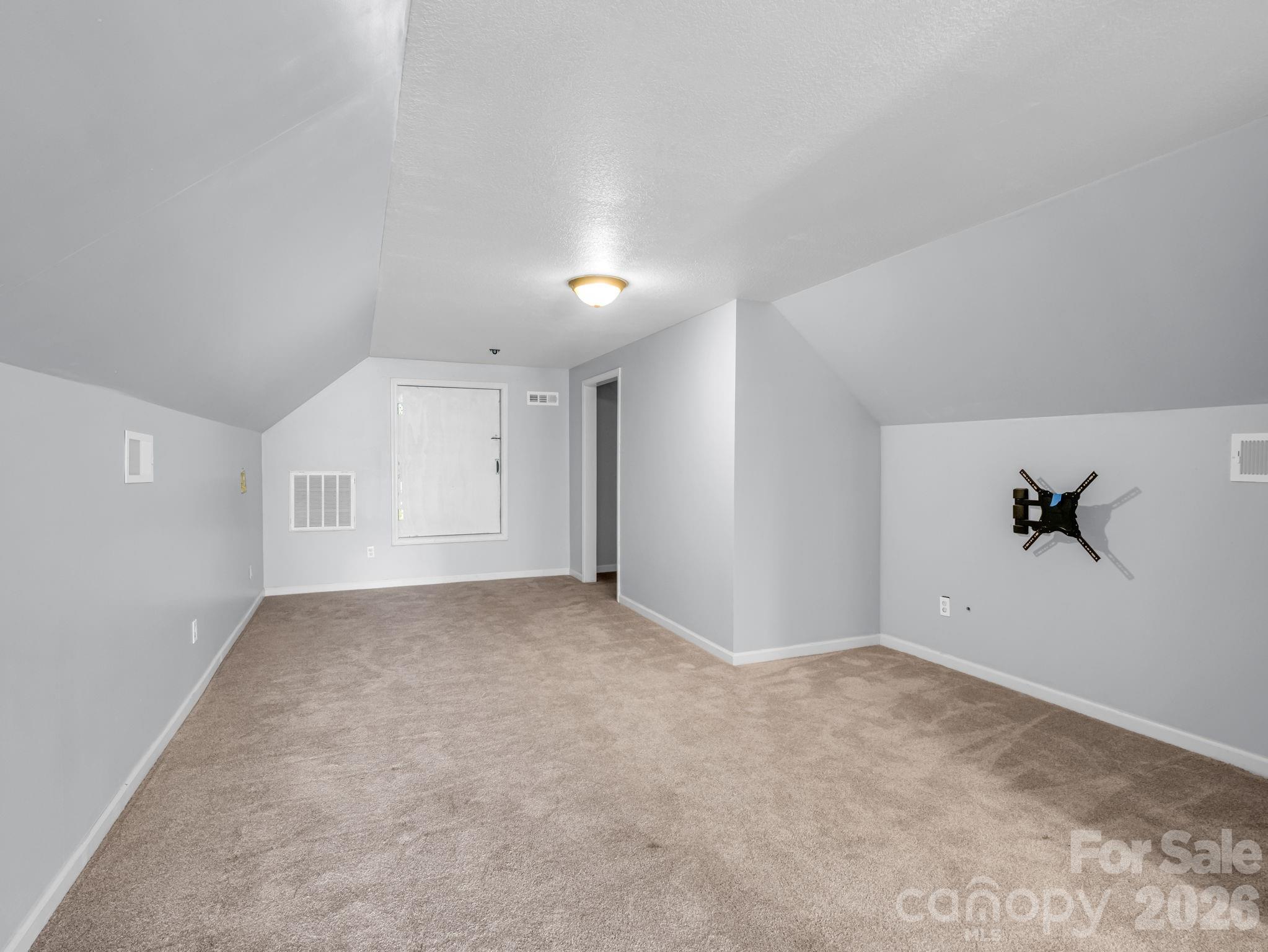 Huge bonus room upstairs; view looking towards large unfinished space above garage and to the right is a spacious storage closet. TV mount will convey. - 355 Hidden Meadow Drive, Hendersonville
