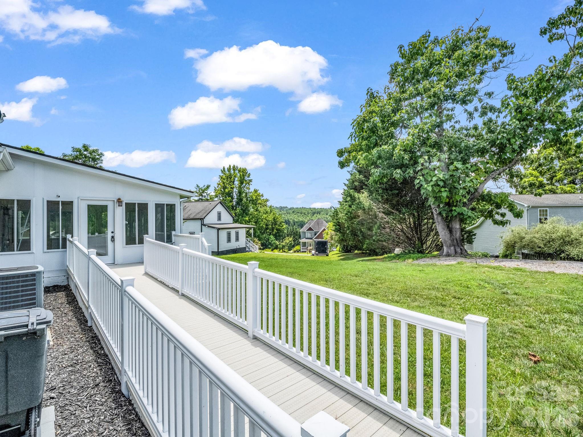 View of ramp towards sunroom. You can see the two separate HVAC units here; one serves the downstairs and the other upstairs. - 355 Hidden Meadow Drive, Hendersonville