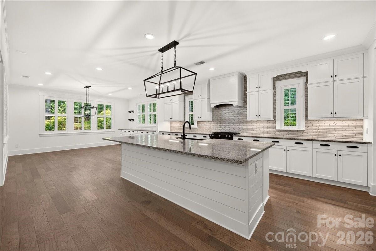 The heart of the home, this beautifully appointed kitchen offers an abundance of workspace with expansive granite countertops, an oversized center island, and exceptional prep space. Thoughtfully designed for both everyday living and entertaining, it features under-cabinet lighting, abundant recessed lighting, and sleek linear pendant fixtures that create a bright, modern ambiance. - 3142 Sherman Drive, Lancaster