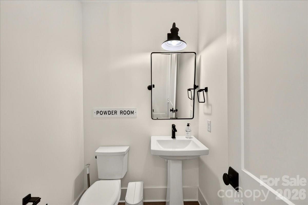 Half bath on main level with prefinished hardwood flooring, pedestal sink, Pottery barn mirror remains Powder room sign has been removed and wall repainted - 3142 Sherman Drive, Lancaster