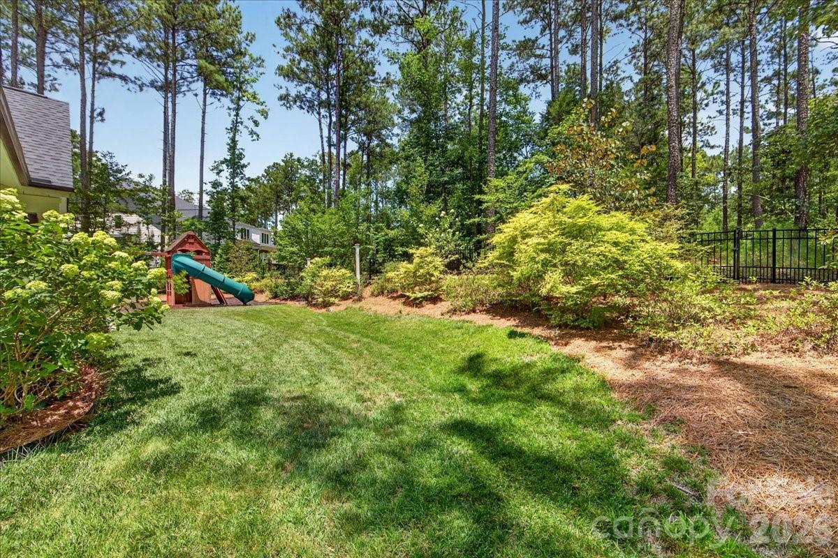 Professionally landscaped back yard area- this lot extends well beyond the fenced area and seller opted to leave the trees for a more natural feel and privacy - 3142 Sherman Drive, Lancaster