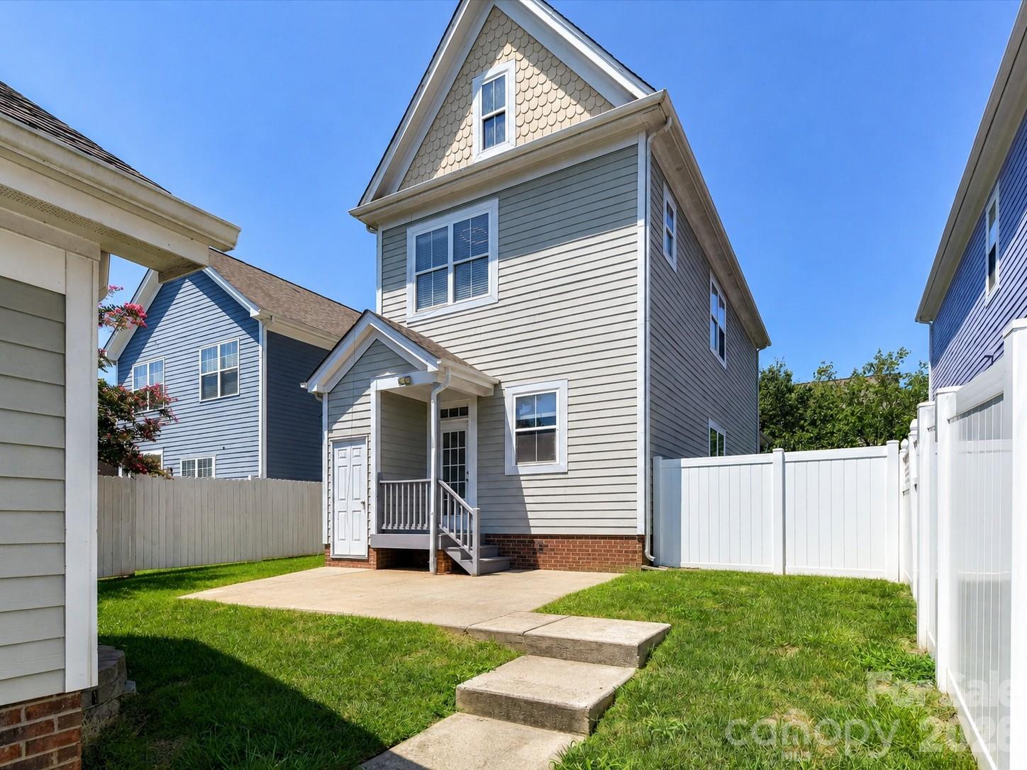 The fenced backyard features a spacious patio, private storage room, and plenty of room for outdoor entertaining, gardening, or everyday enjoyment. - 13106 Kennerly Drive, Huntersville