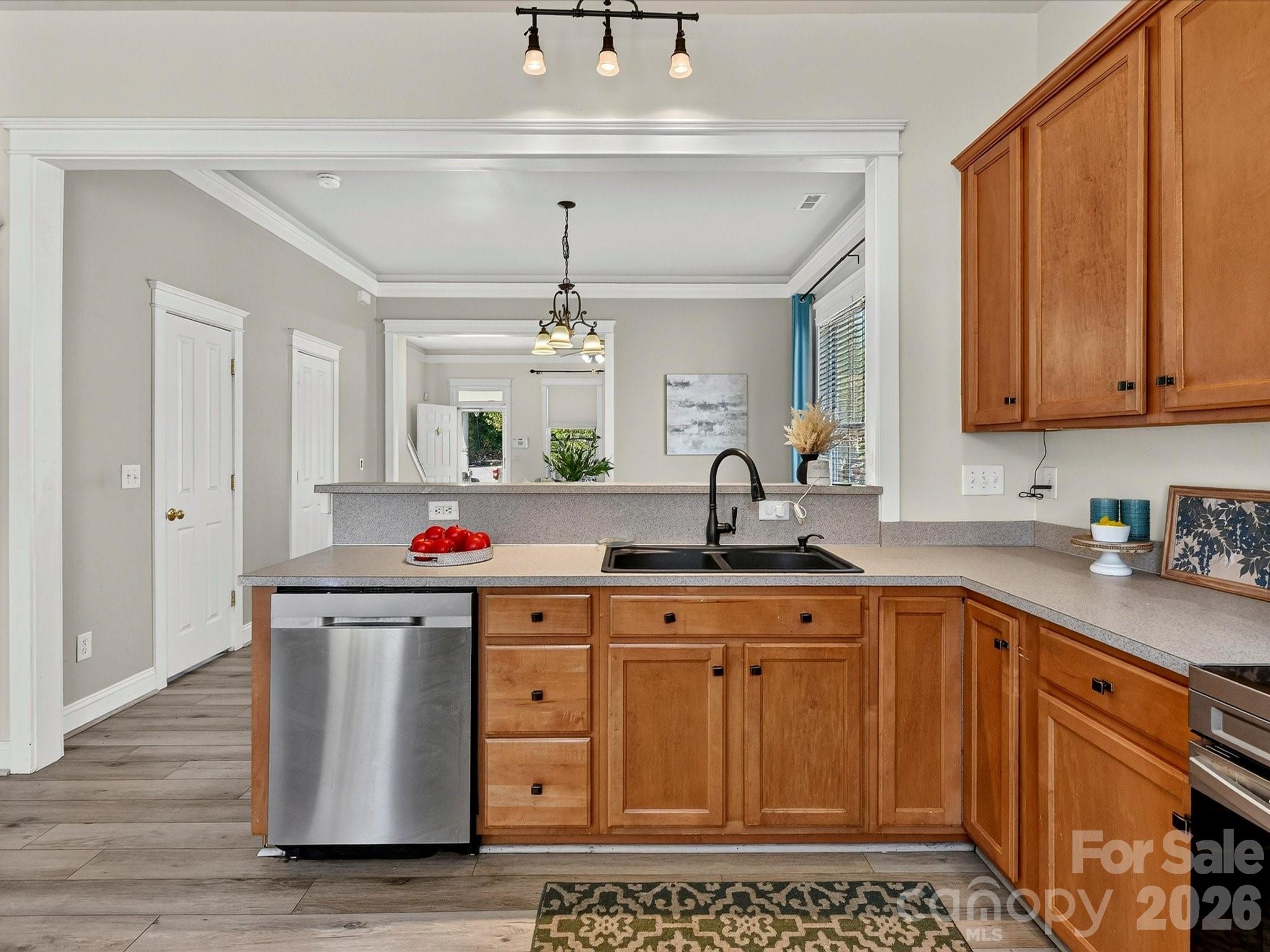 A functional layout highlights this inviting kitchen with extensive cabinetry, ample workspace, stainless steel appliances, a breakfast bar for casual seating, and direct access to the rear patio for easy indoor-outdoor living. - 13106 Kennerly Drive, Huntersville
