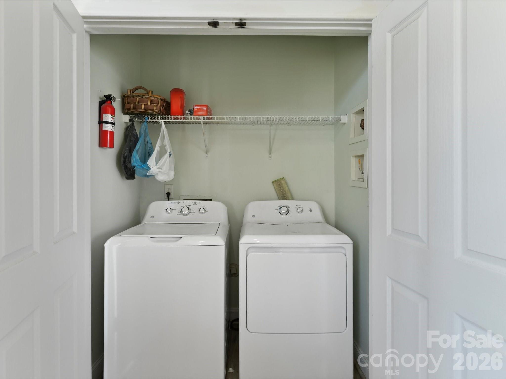 The conveniently located laundry area includes upper shelving for storage and provides a practical space to simplify everyday household tasks. - 13106 Kennerly Drive, Huntersville