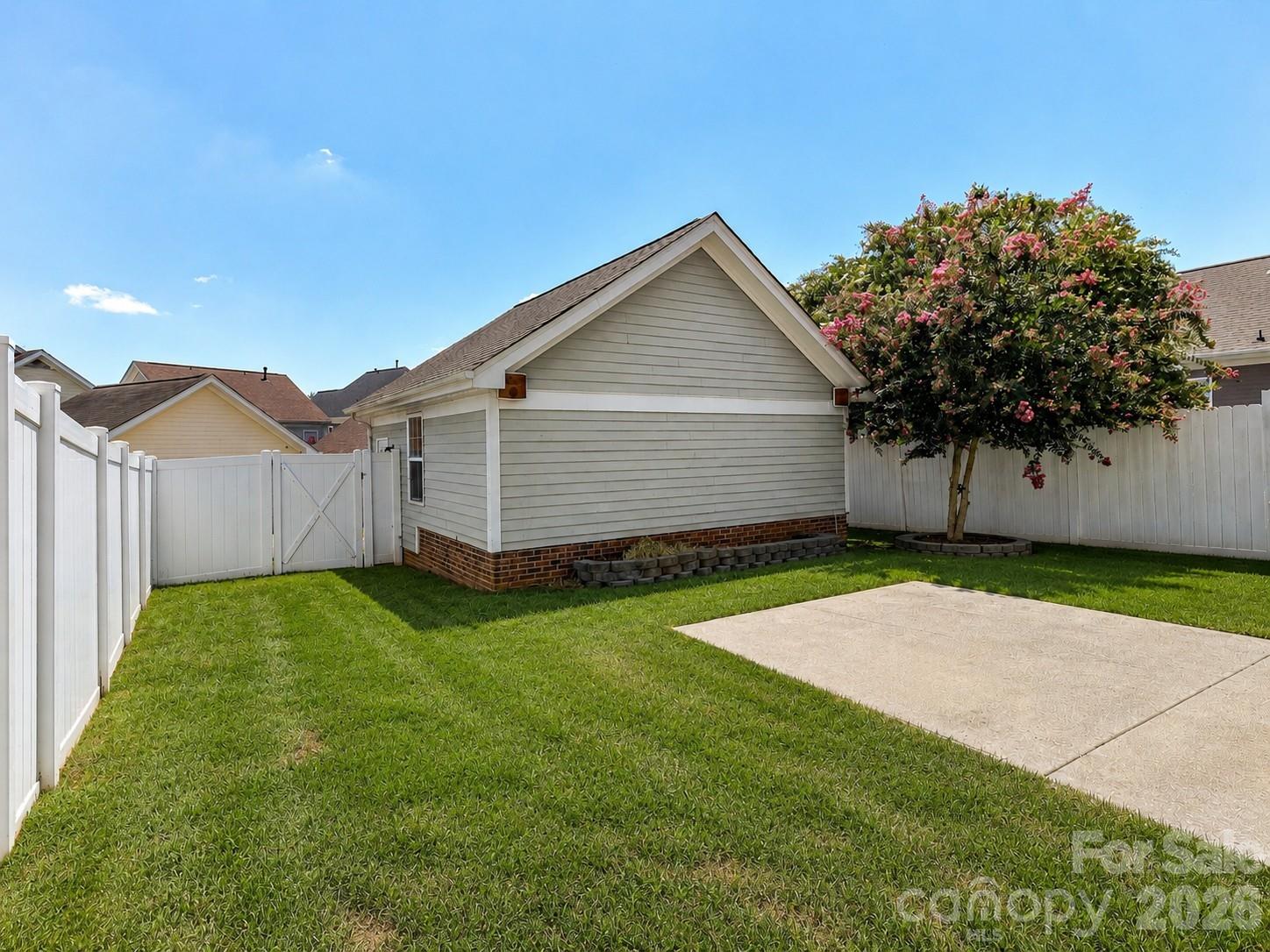 The fully fenced backyard & access to the detached 2 gar garage offers a spacious lawn, gated access, and a private outdoor setting perfect for relaxing, entertaining, or play. - 13106 Kennerly Drive, Huntersville