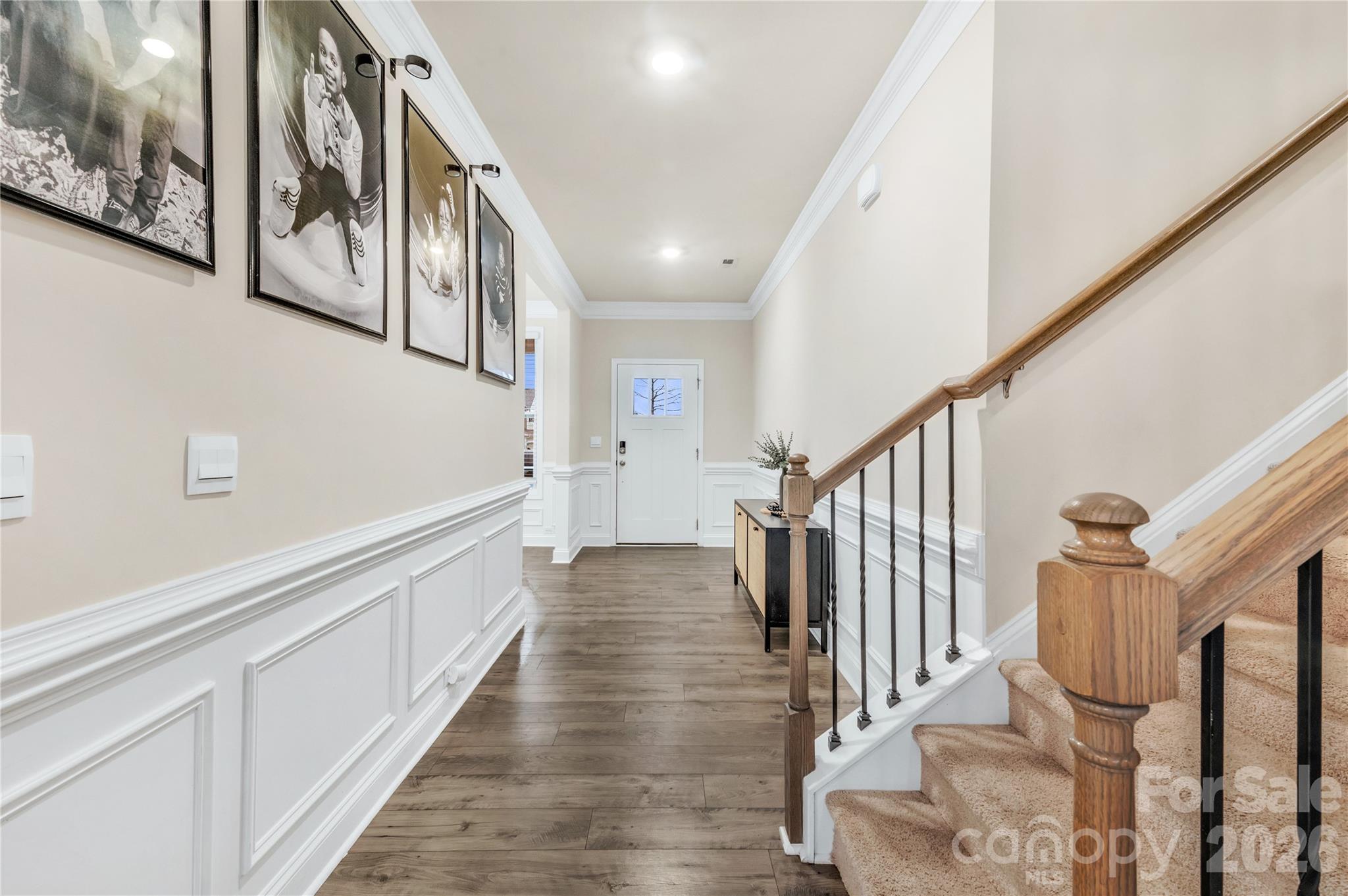 As you enter this home, you are greeted by extensive white wainscoting and crown molding with beautiful revwood flooring - 4849 Tacoma Drive, Fort Mill