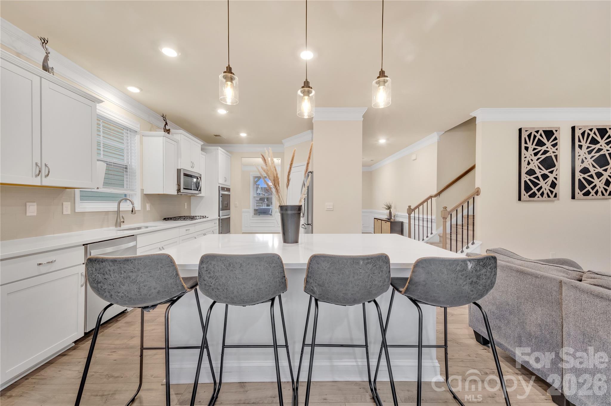 A massive center island offers ample workspace and casual seating illuminated by chic pendent lighting. - 4849 Tacoma Drive, Fort Mill