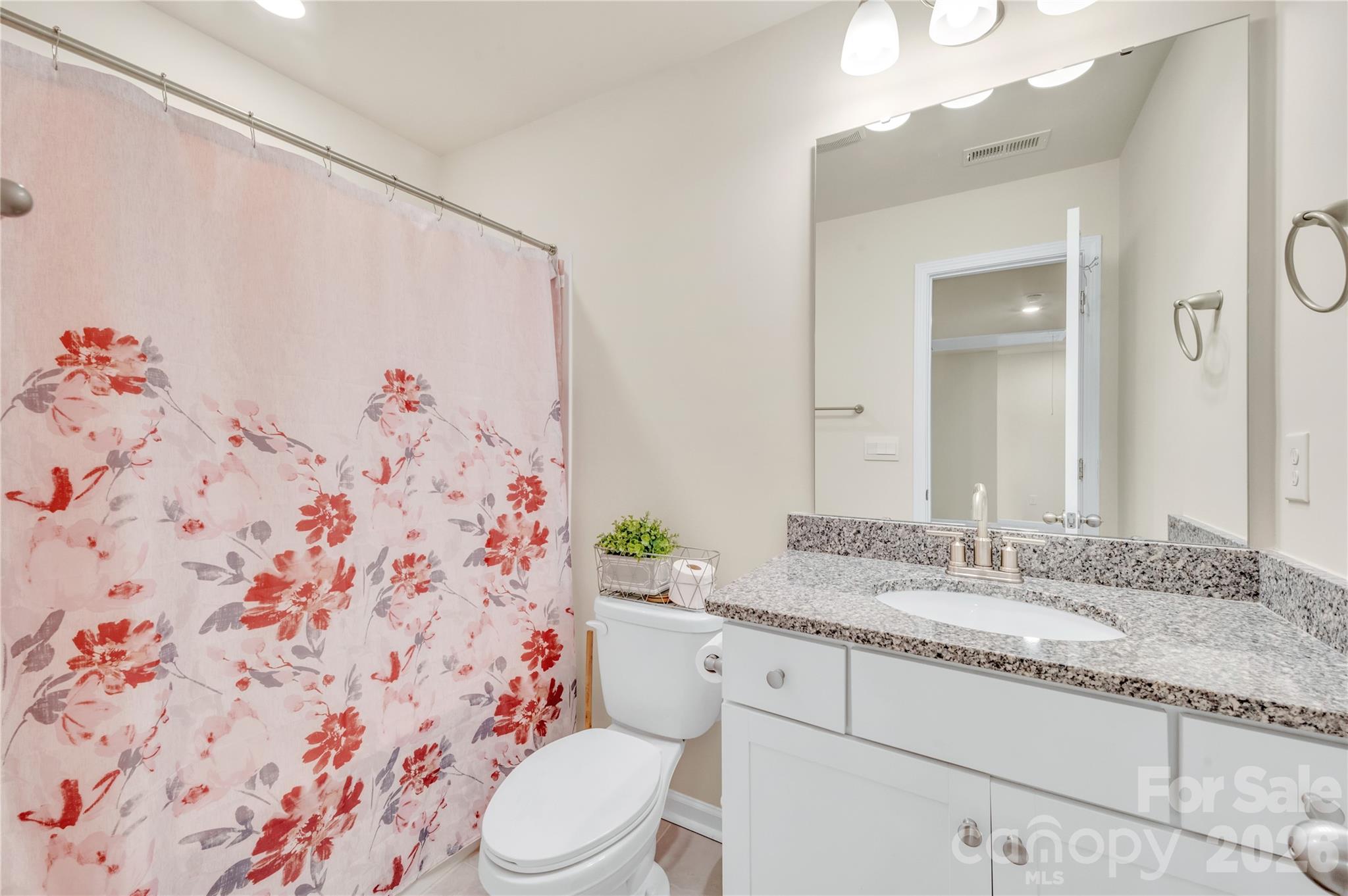 This pristine full bath features a stylish granite-topped vanity with an undercounted sink and timeless white cabinetry. - 4849 Tacoma Drive, Fort Mill