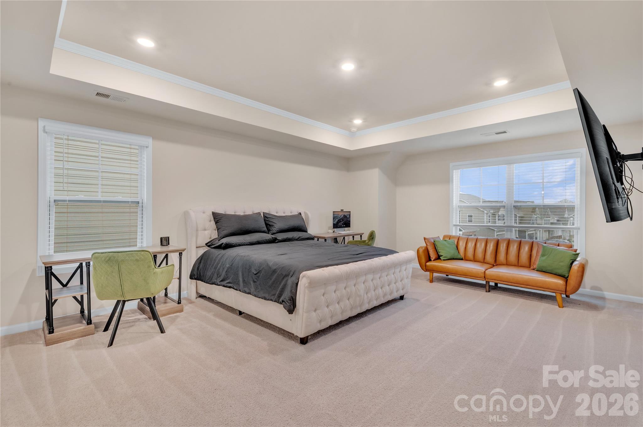 A luxurious escape within the home, this massive primary bedroom features stunning tray ceiling with crisp crown molding and recessed lighting. - 4849 Tacoma Drive, Fort Mill