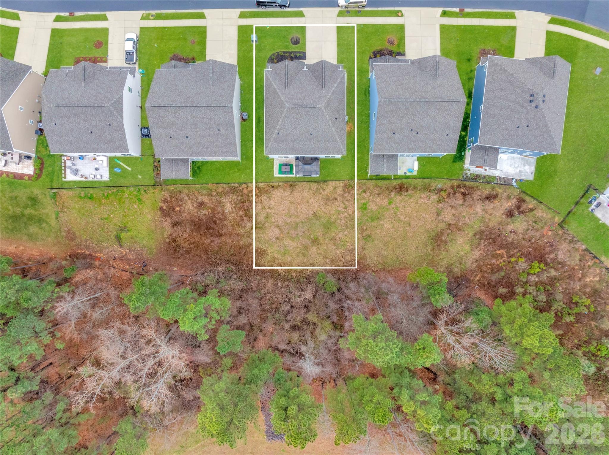 This exceptional aerial perspective highlights the impressive depth and premier positioning of the protected wooded buffer. The generous lot line extends well past the home, offering expansive outdoor space perfect for future customization - 4849 Tacoma Drive, Fort Mill
