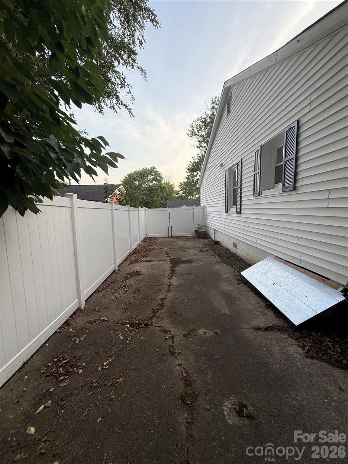 The fence on the side gives privacy and added space for car. - 4220 Harvard Avenue, Greensboro