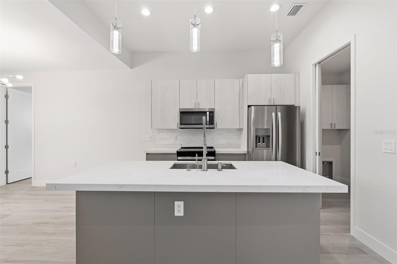 Sleek Kitchen with Quartz Island and Two-Toned Cabinetry - 14319 ALLENSWORTH AVE, PORT CHARLOTTE
