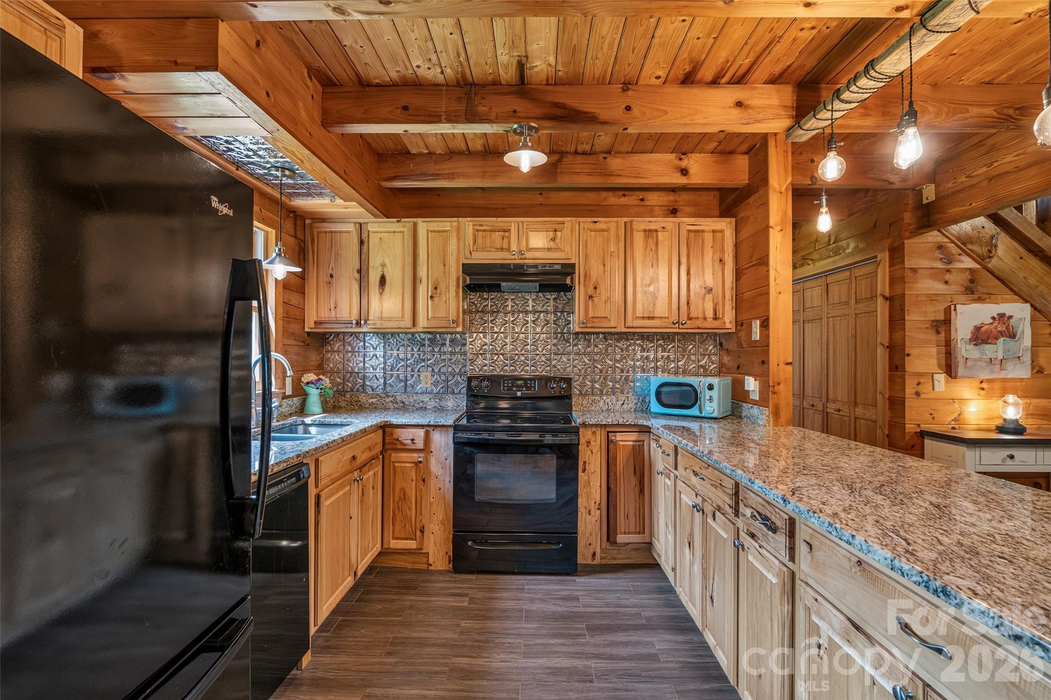 Kitchen has ample cabinets plus tin backsplash/accents for added charm - 4551 Lake Adger Parkway, Mill Spring