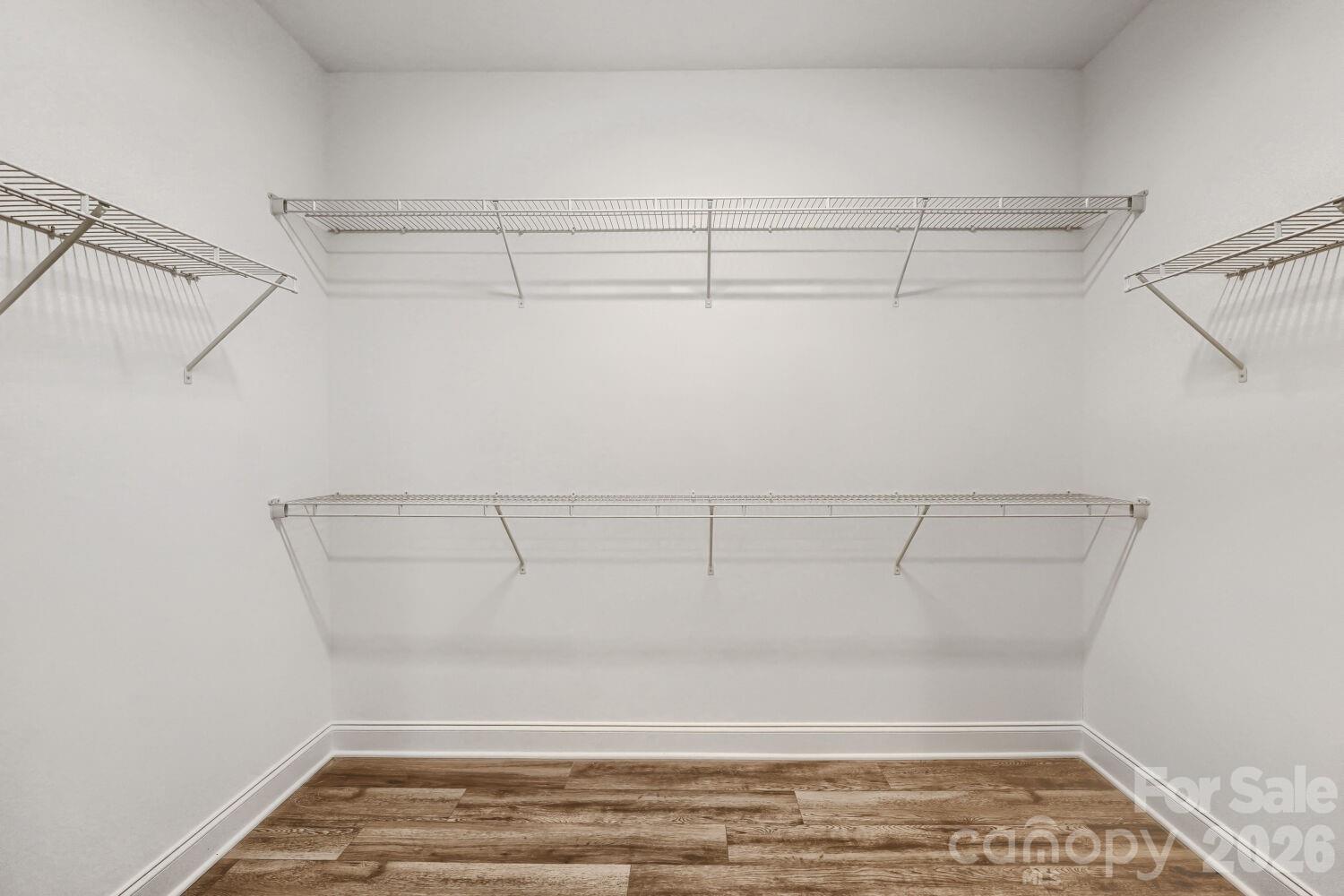 A generous walk-in closet outfitted with tiered wire shelving on multiple walls. Plenty of hanging and storage space keeps everything organized. - 2358 Fay Jones Road, Denver