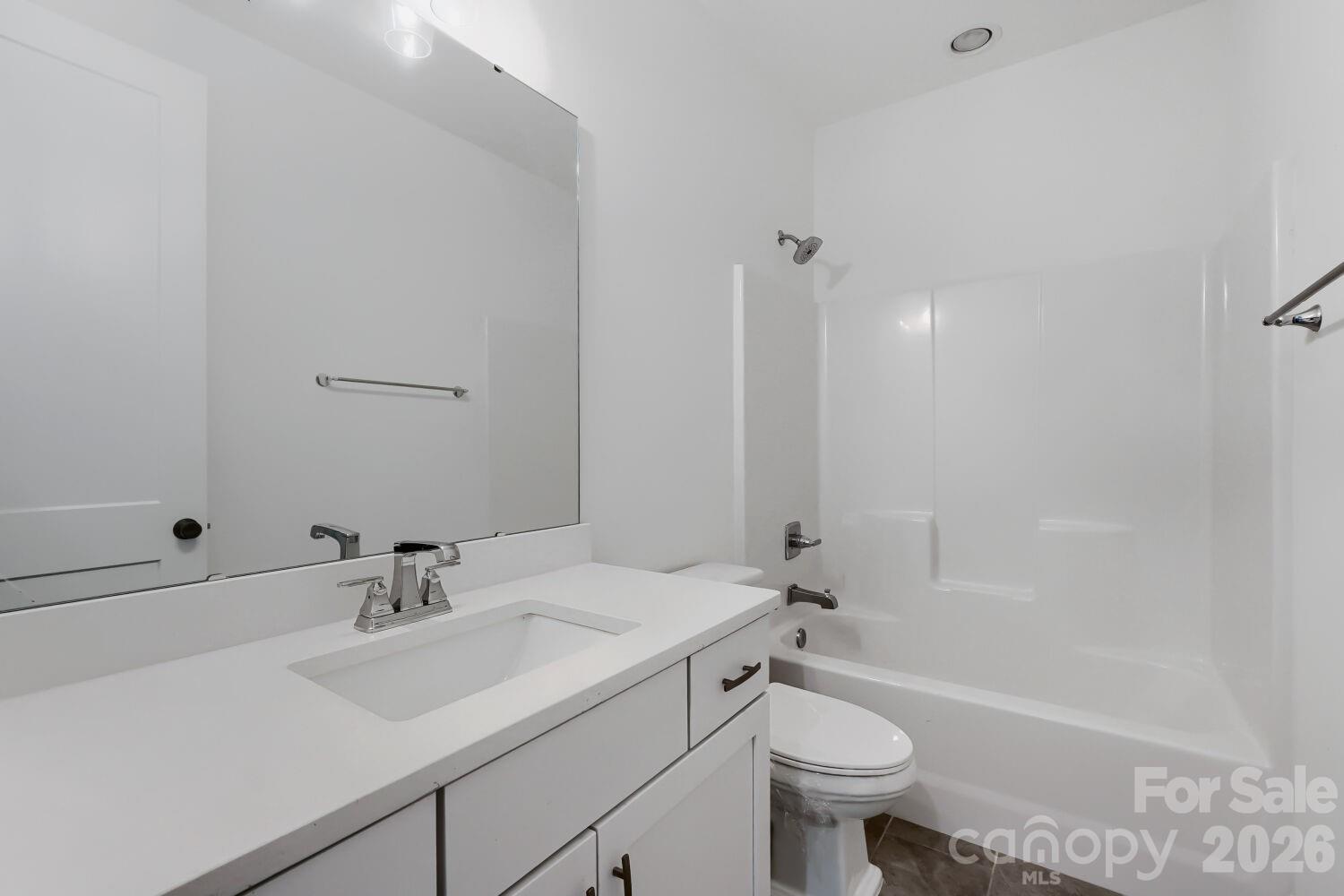 This full guest bathroom features a sleek quartz-topped vanity with a chrome faucet and a bright tub-shower combo. Crisp white finishes and modern fixtures make the space feel clean and move-in ready. - 2358 Fay Jones Road, Denver