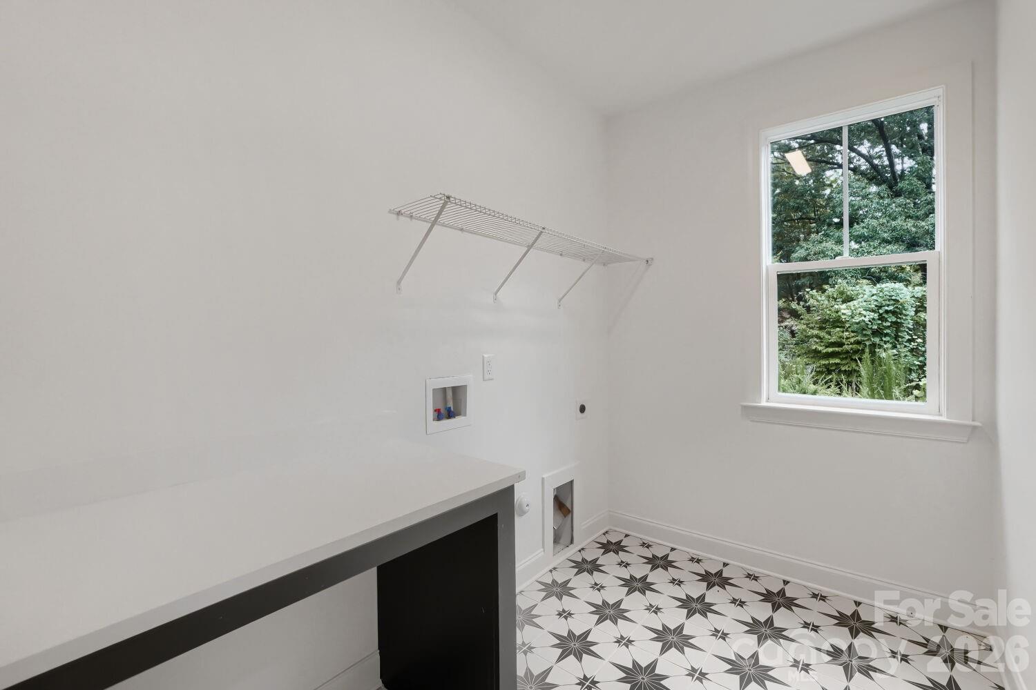 A covered back patio offering a shaded spot to relax and take in the wooded surroundings. The lush, private backdrop is perfect for outdoor enjoyment. - 2358 Fay Jones Road, Denver