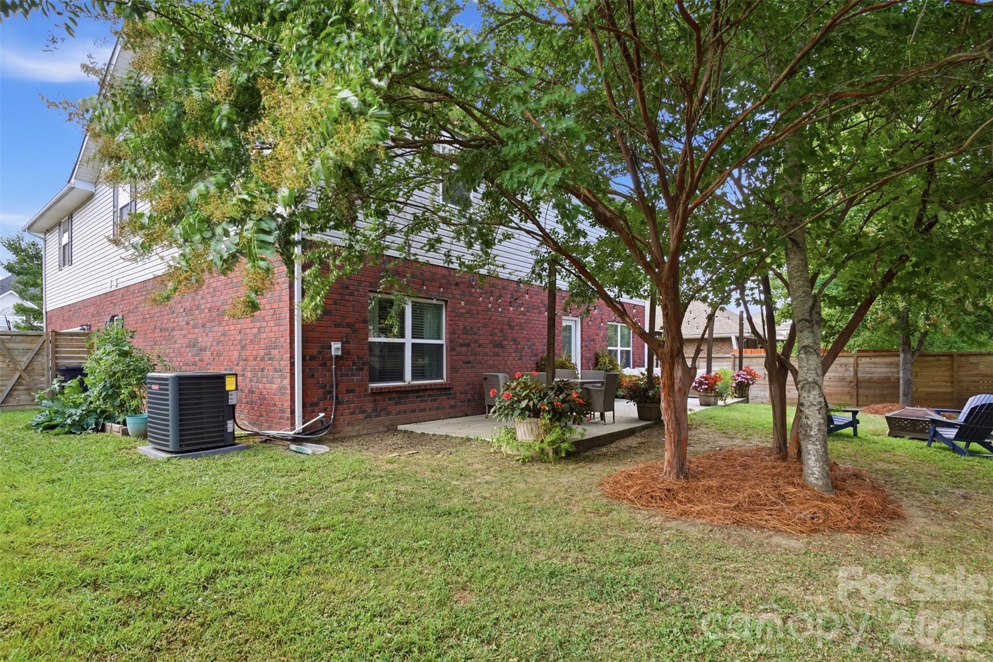 Side yard has a raised garden bed to the left and the portable fire pit area on the right! - 835 Estuary Court, Rock Hill
