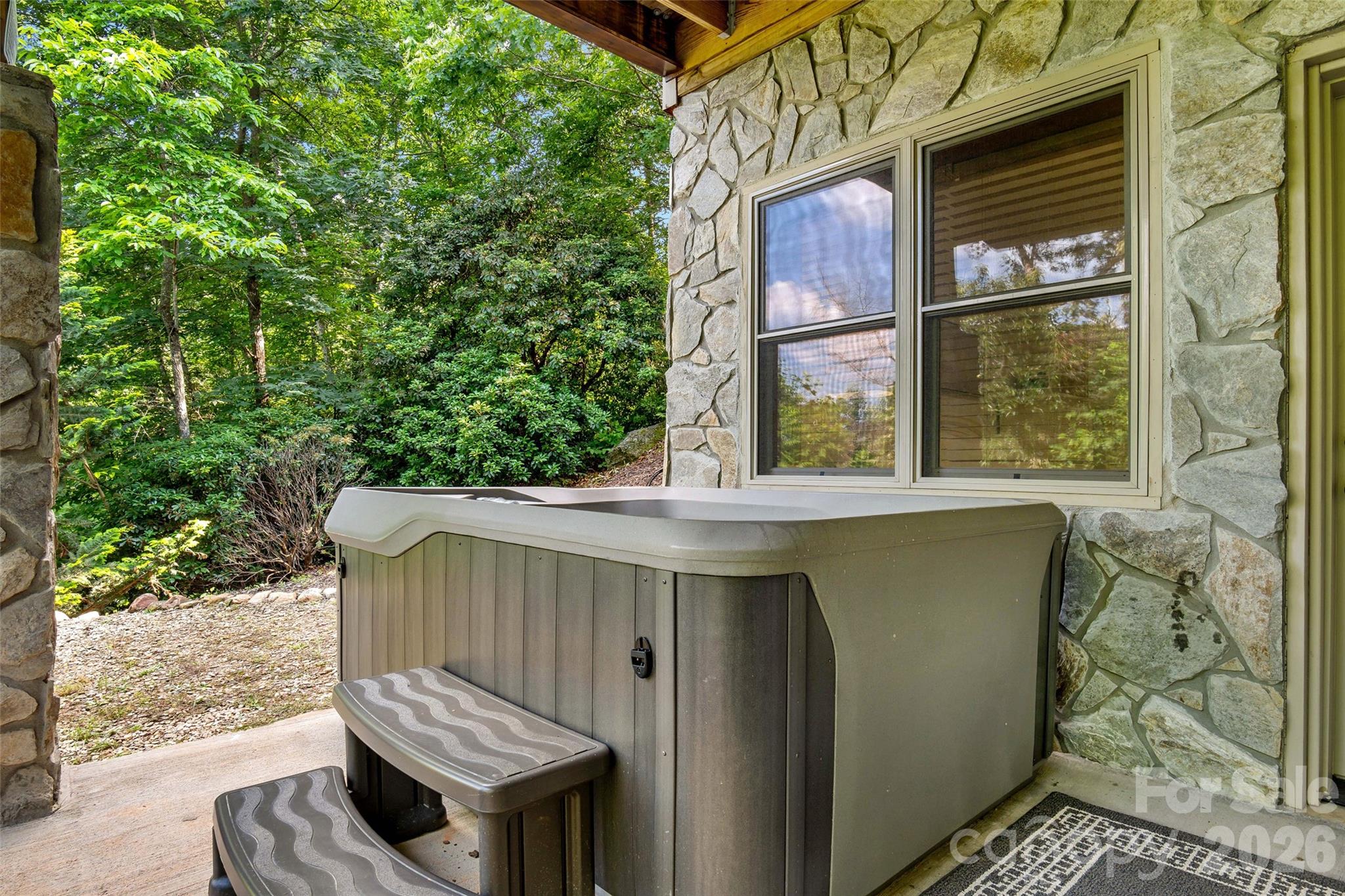 Unwind in the hot tub overlooking the fire pit and outdoor gathering area. - 179 Rock Spring Road, Lake Lure
