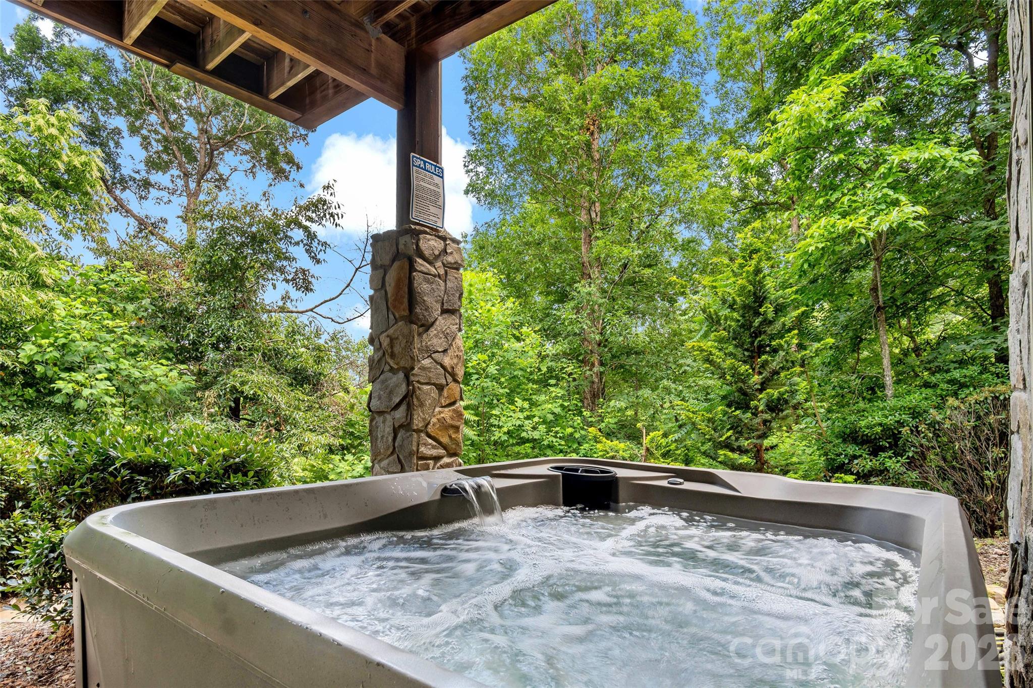 Unwind in the hot tub overlooking the fire pit and outdoor gathering area. - 179 Rock Spring Road, Lake Lure