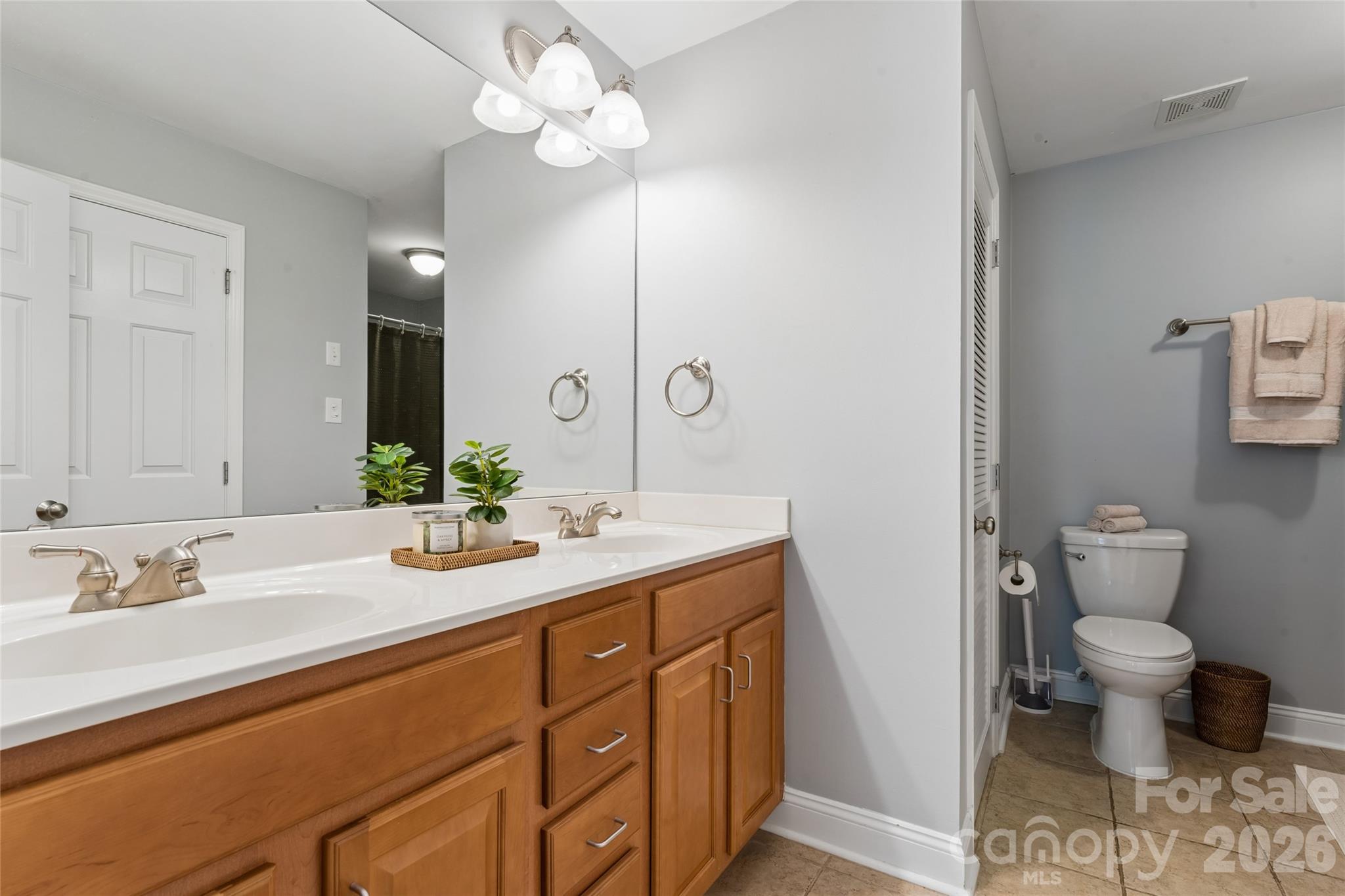 Dual Vanities in Primary Bathroom; Utility closet is beside of the toilet - 1806 Fairlawn Court, Rock Hill