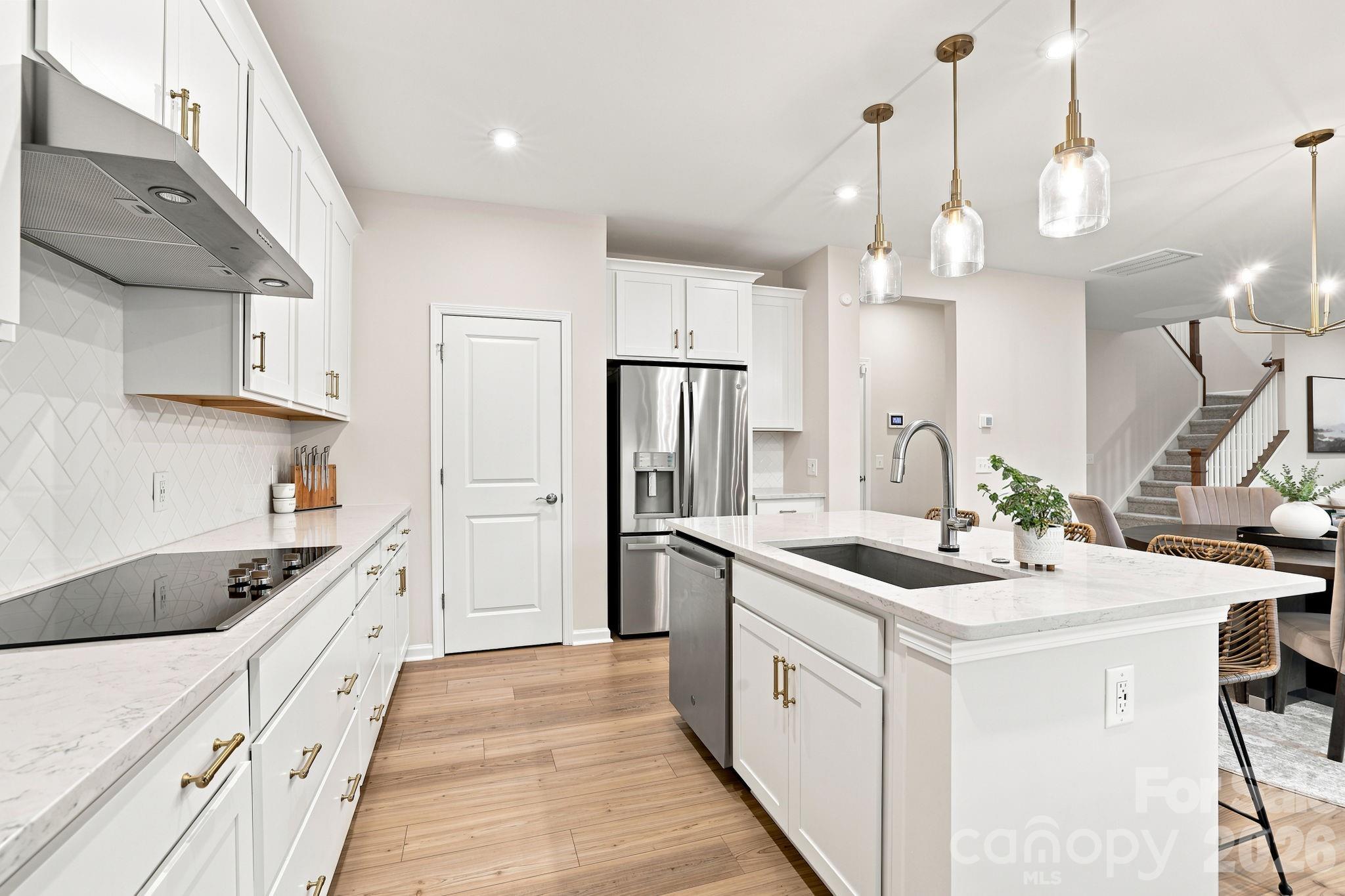 Pendant lighting at Kitchen island brings good lighting while sitting at the bar. LVP is throughout. And recessed lighting is plus! - 8226 Franklin Trail Street, Mint Hill