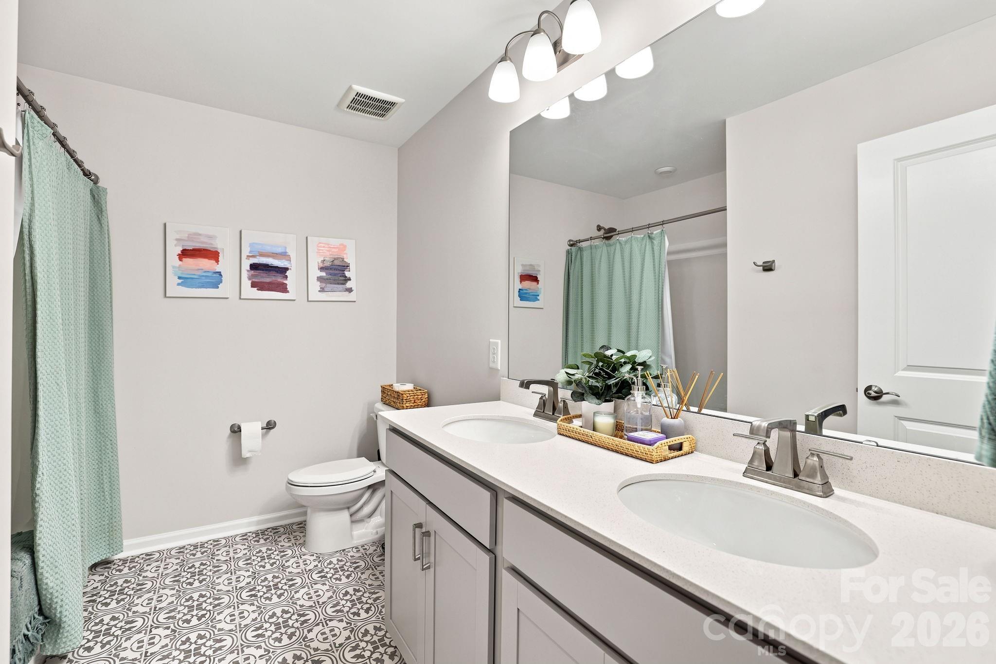 Full hall bath with dual sinks and designer tile flooring. - 8226 Franklin Trail Street, Mint Hill