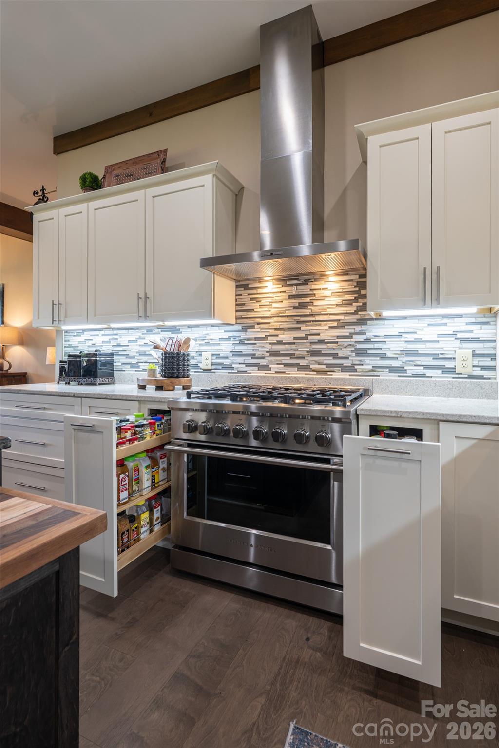 Dual pull-out spice drawers flank the range, offering smart storage and quick access while cooking. - 660 Pleasant Grove Road, Hendersonville
